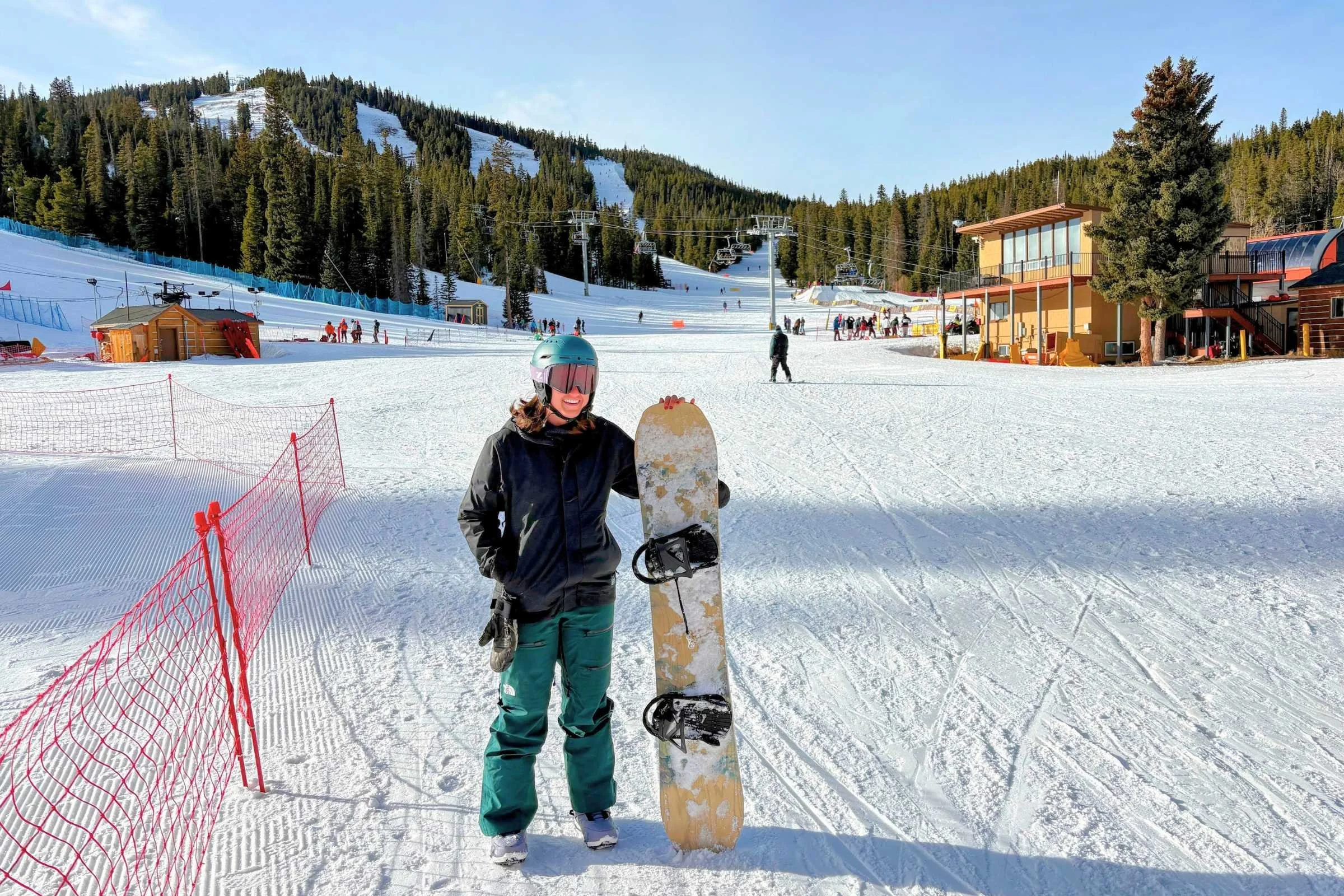 Snowboarder wearing REI Co-op Powderbound Insulated snowboard jacket riding on a snowy mountain slope