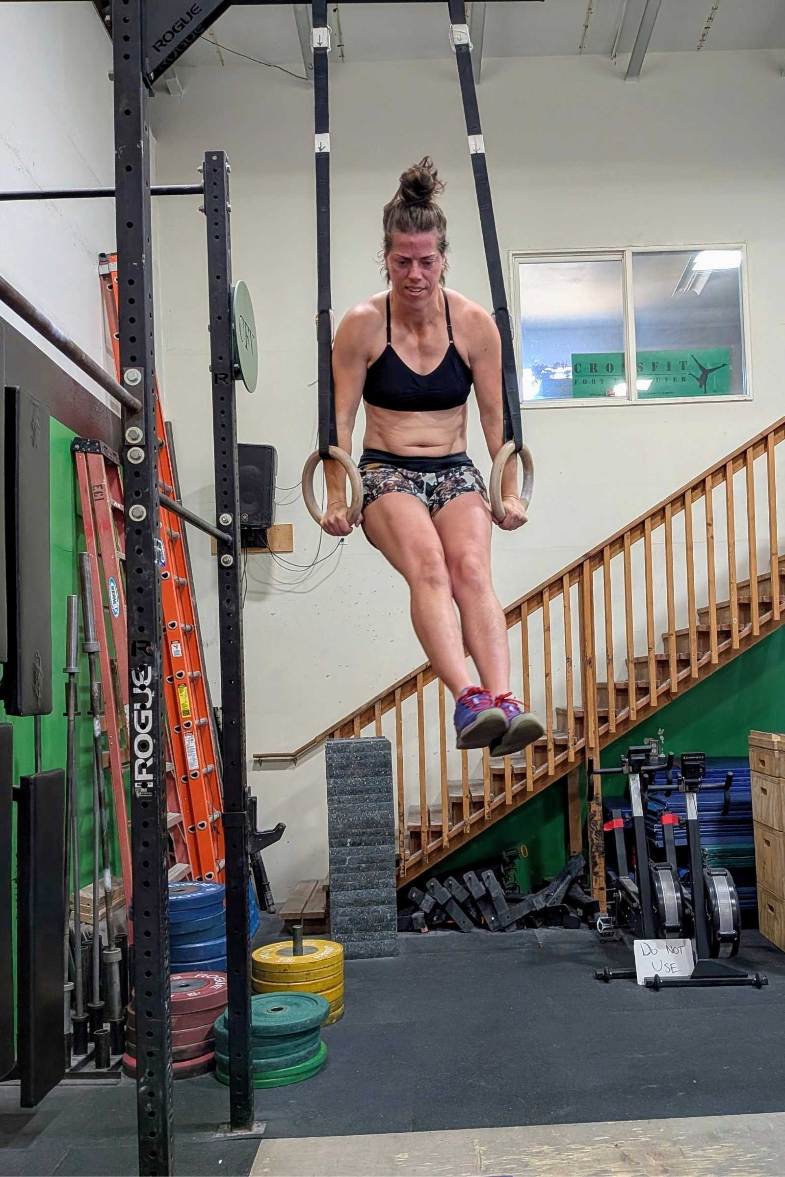 Full view of Treeline writer and tester Kate Hoch wearing the Title Nine Wanna Sweat Racerback sports bra while doing ring muscle ups in CrossFit. Photo by Kate Hoch.