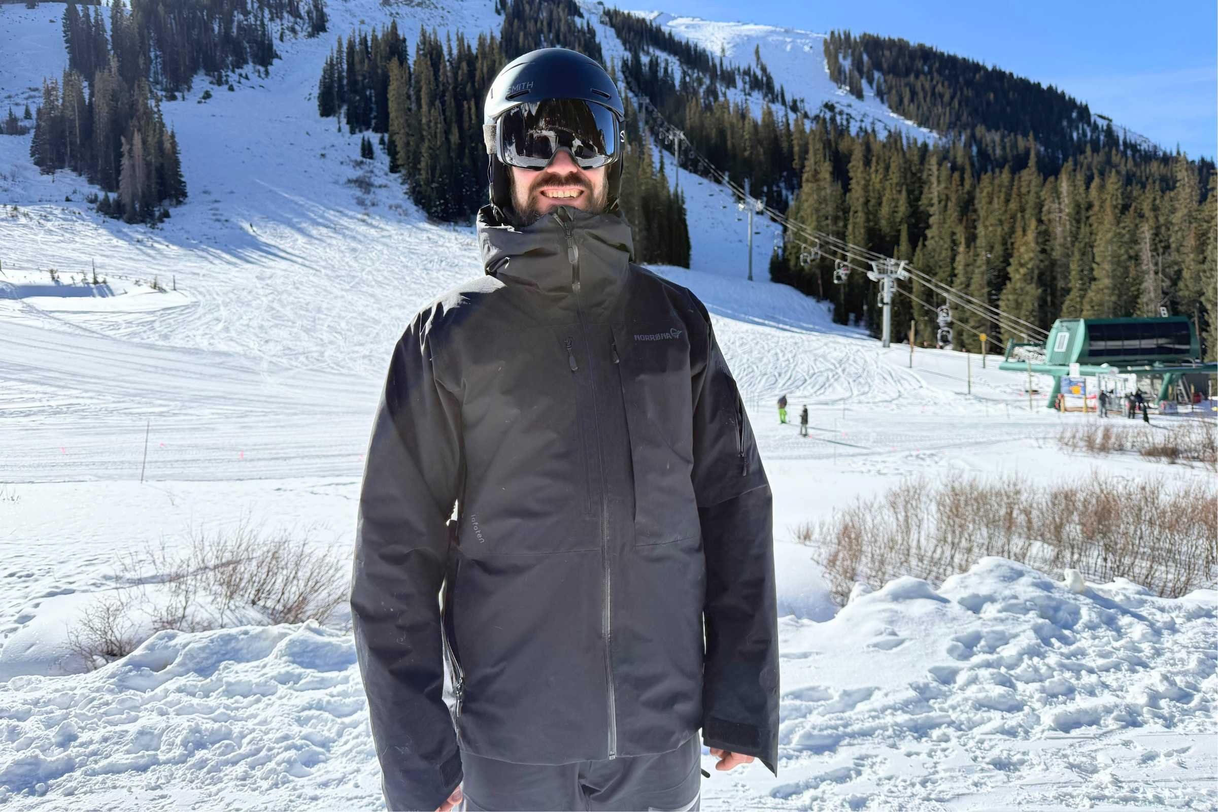 skier wearing the Norrona Lofoten GORE-TEX Insulated Ski Jacket with slopes in the background