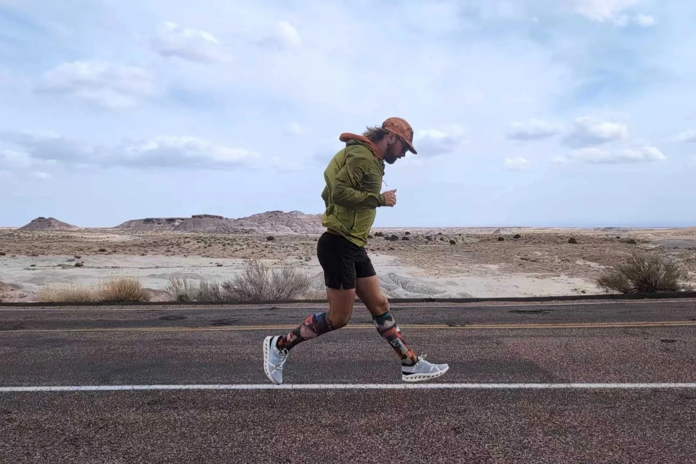 Man running on a desert road wearing the On Cloudsurfer 2 running shoes.