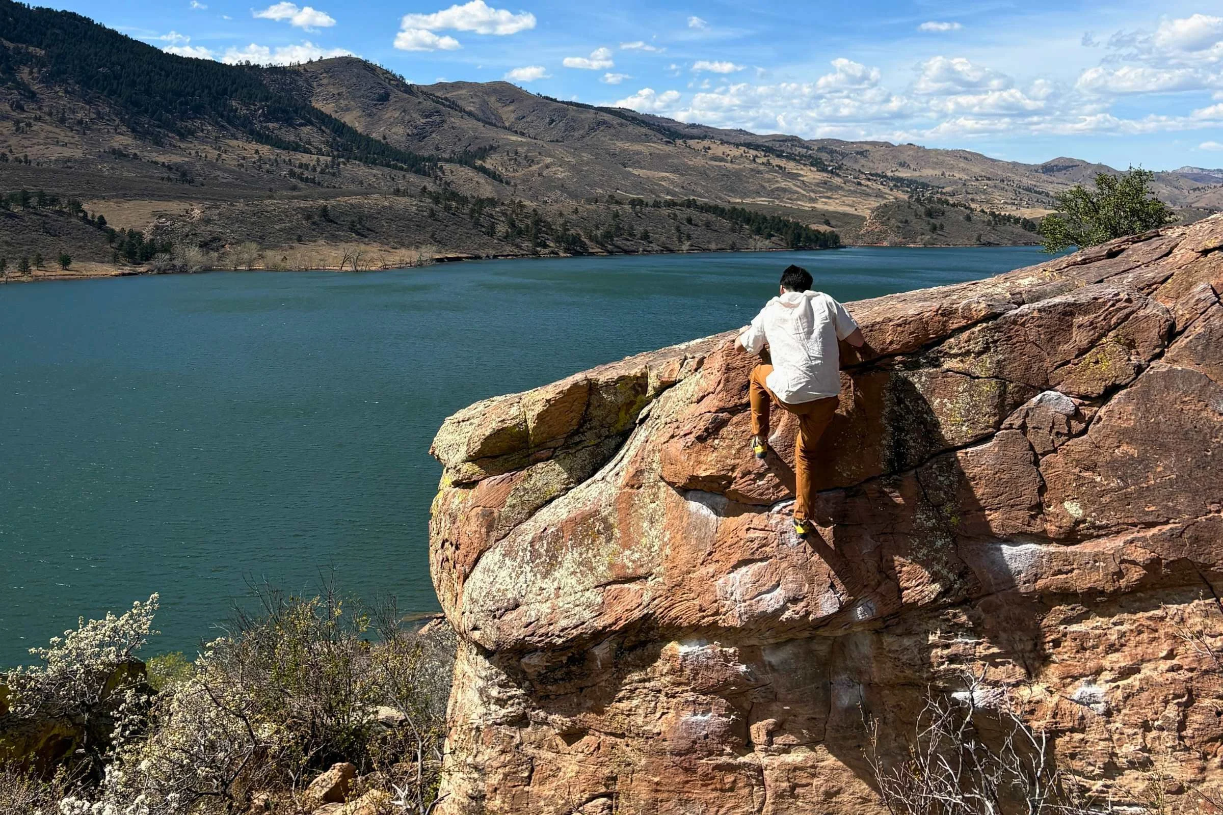 Climber topping out a boulder outside wearing La Sportiva Solution Comps