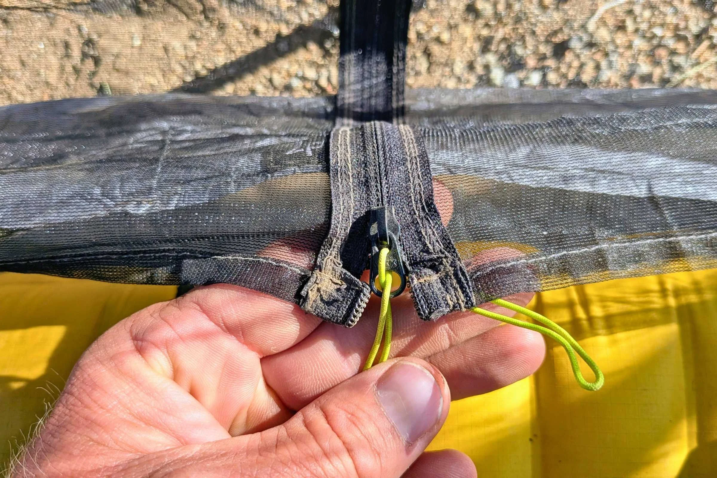 hand holds the zipper pull of Zpacks Hexamid Ultralight Tent