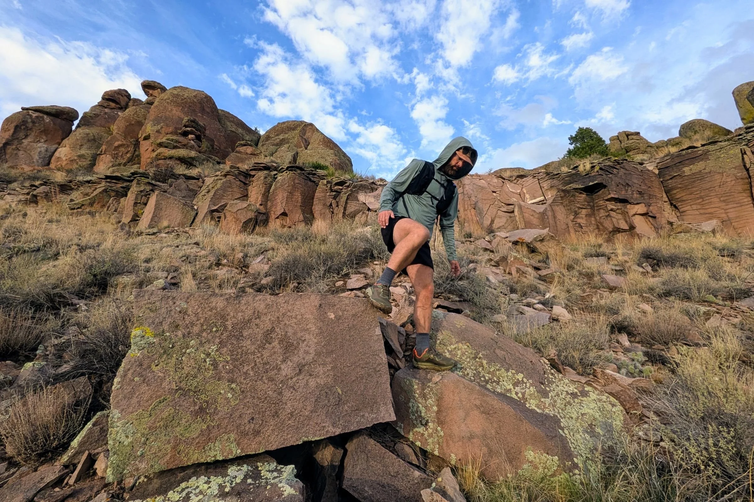Man wearing Altra Olympus 7 shoes on rocky terrain.
