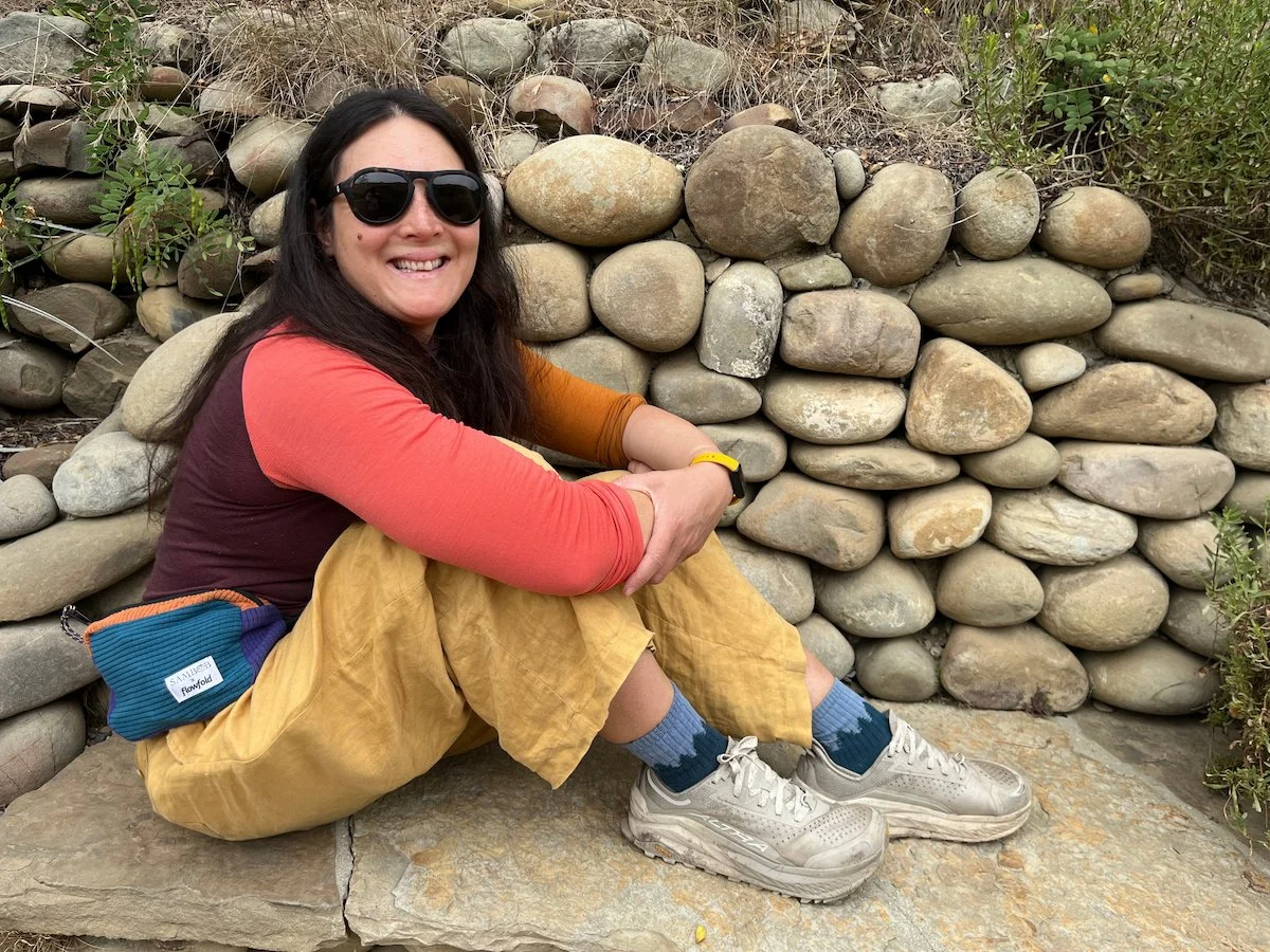 Liz Thomas testing the Darn Tough Hiker socks with a rock wall in the background