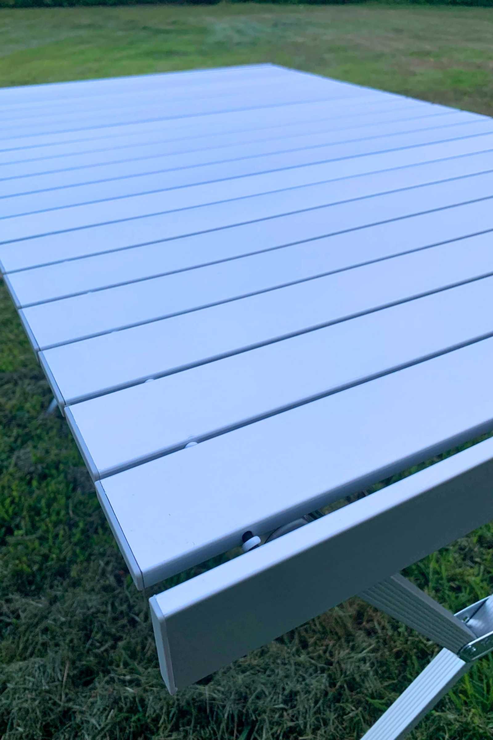 Close up of the metal slats that make up the Alps Mountaineering Dining Table. The metal slats have a negligible gap between them with plastic spacers.
