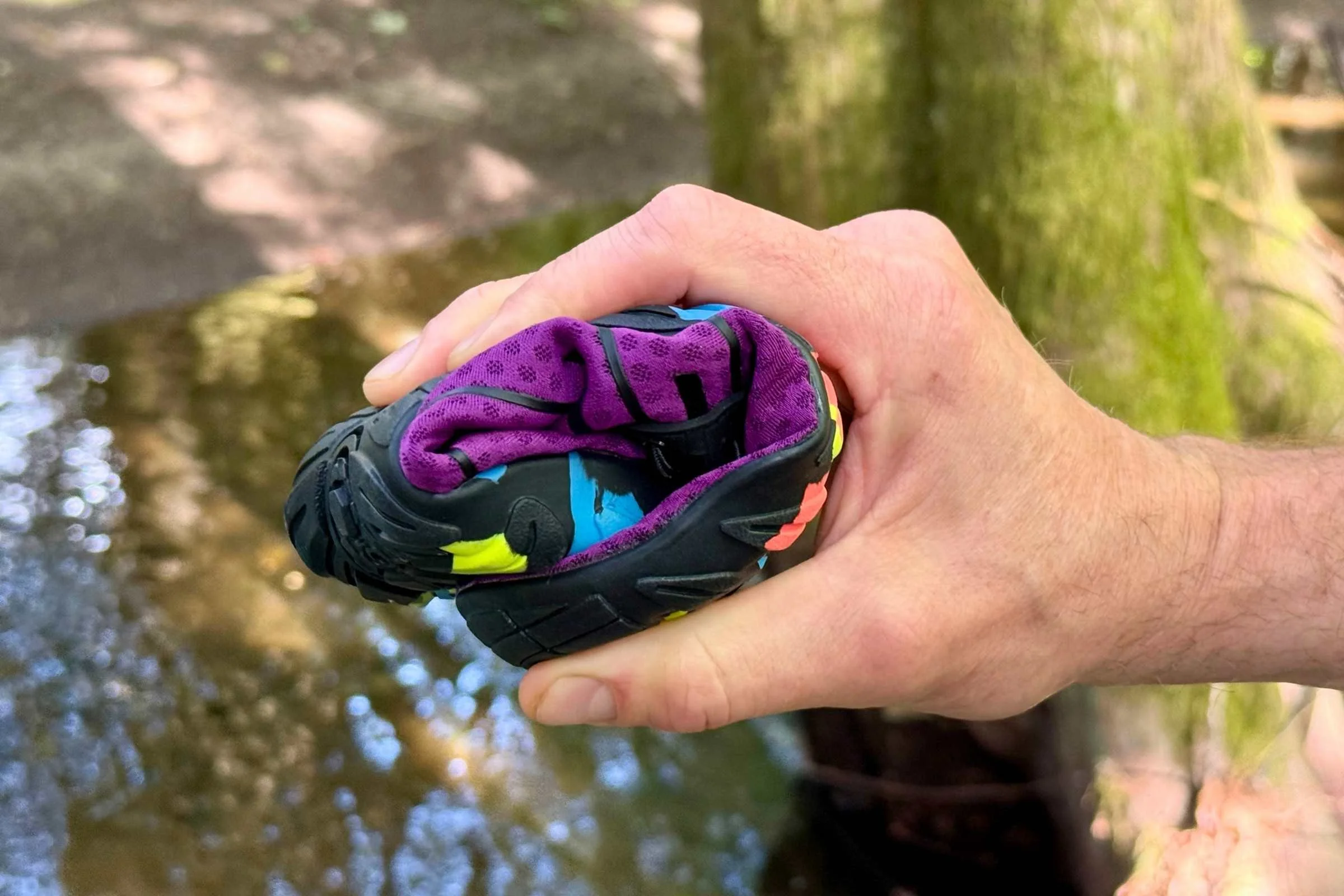 Flexible minimalist water shoe bent in hand