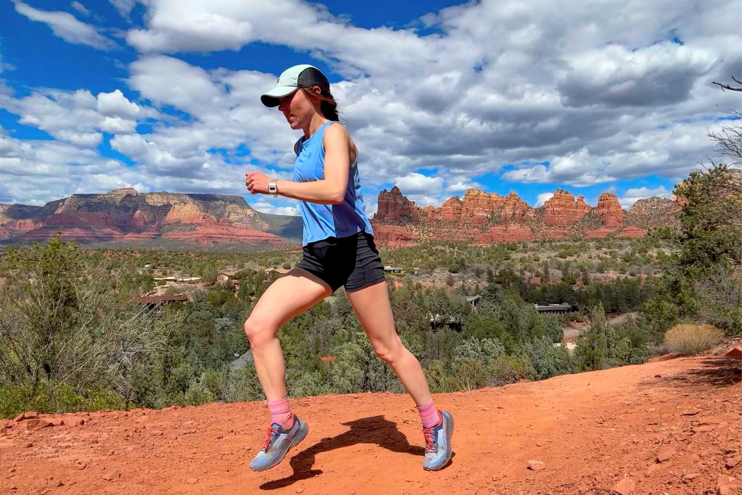 Woman running on a dirt trail while testing trail running shoes