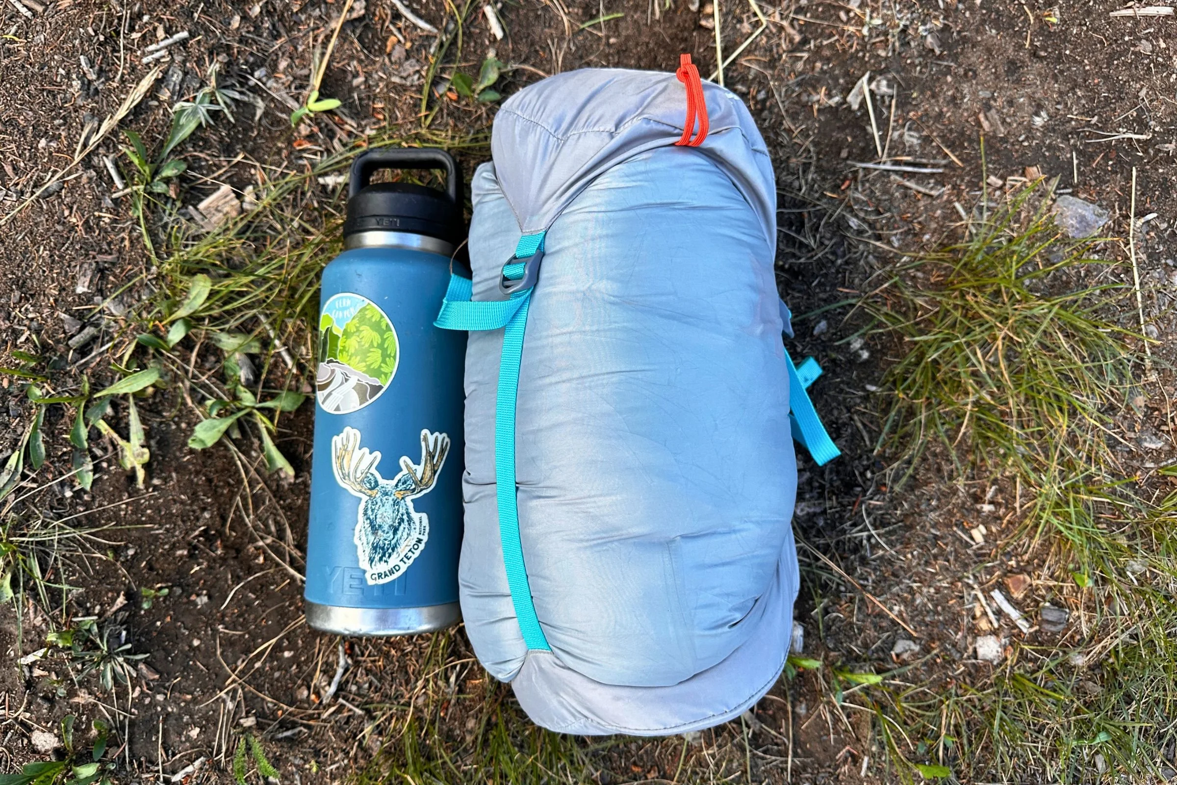 The Therm-a-Rest Boost 650 in its compression sack next to a 46 oz Yeti Rambler water bottle.