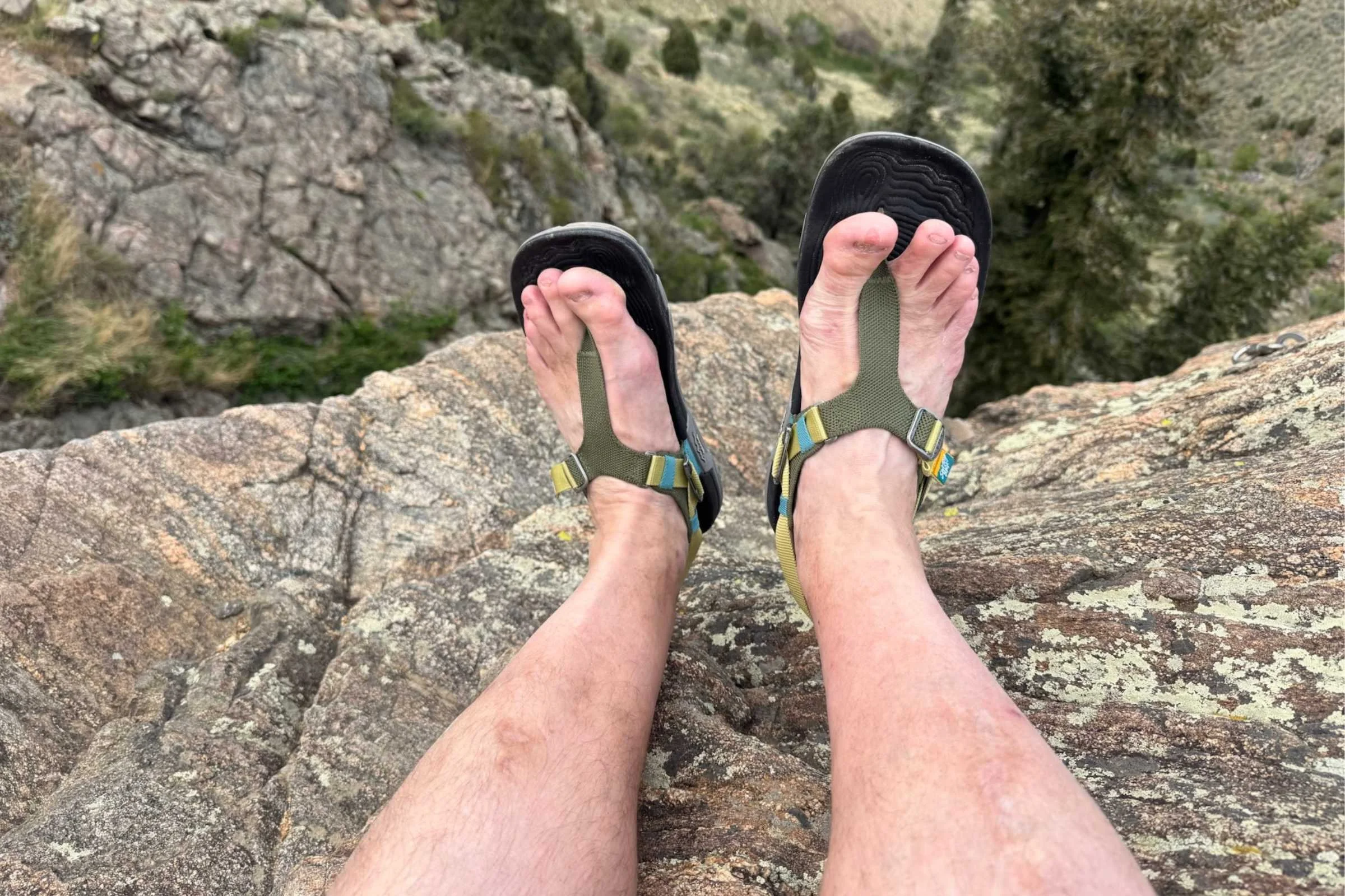 Dangling feet off a rocky outcropping in the Lems Switchback Sandal Knit
