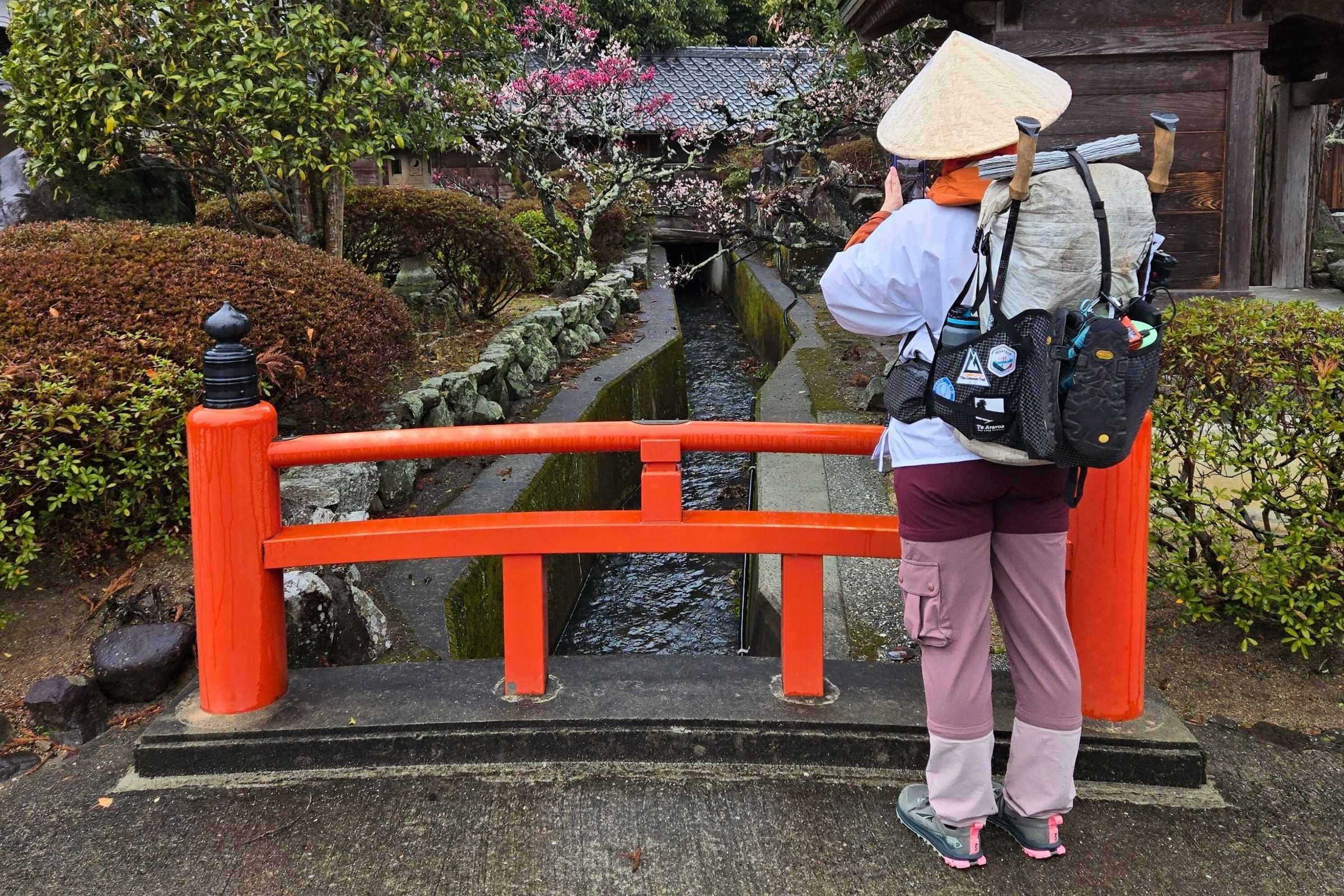 Pilgrim taking a photo at a river in Japan