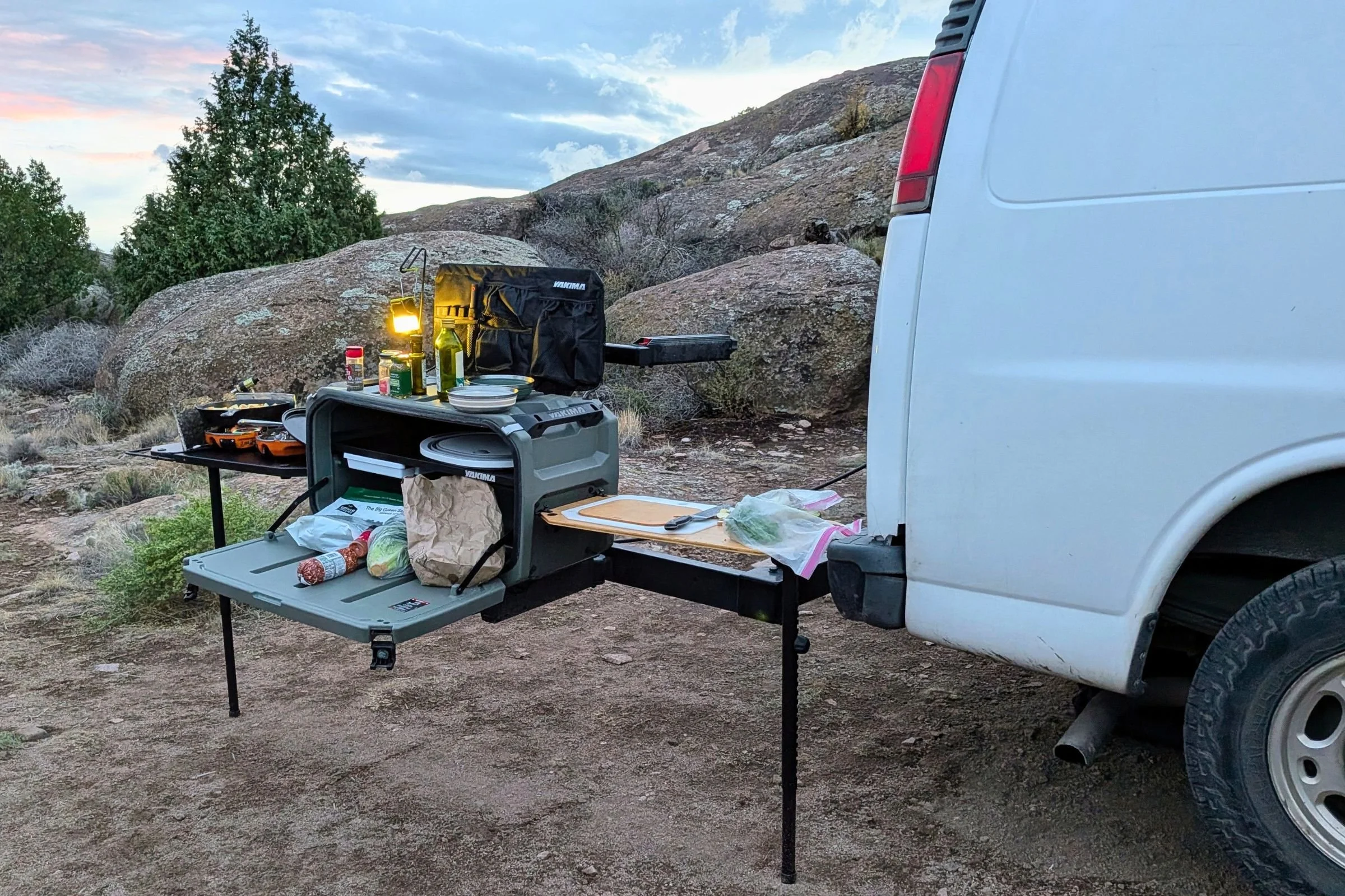 Yakima EXO OpenRange fully set up beside a vehicle with a grill and food-preparation area.