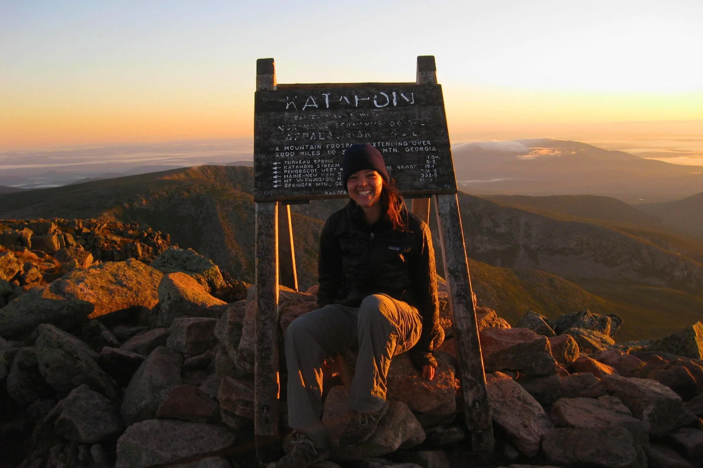 Mary Beth Skylis, author, sitting next to the Katahdin Trail sign.