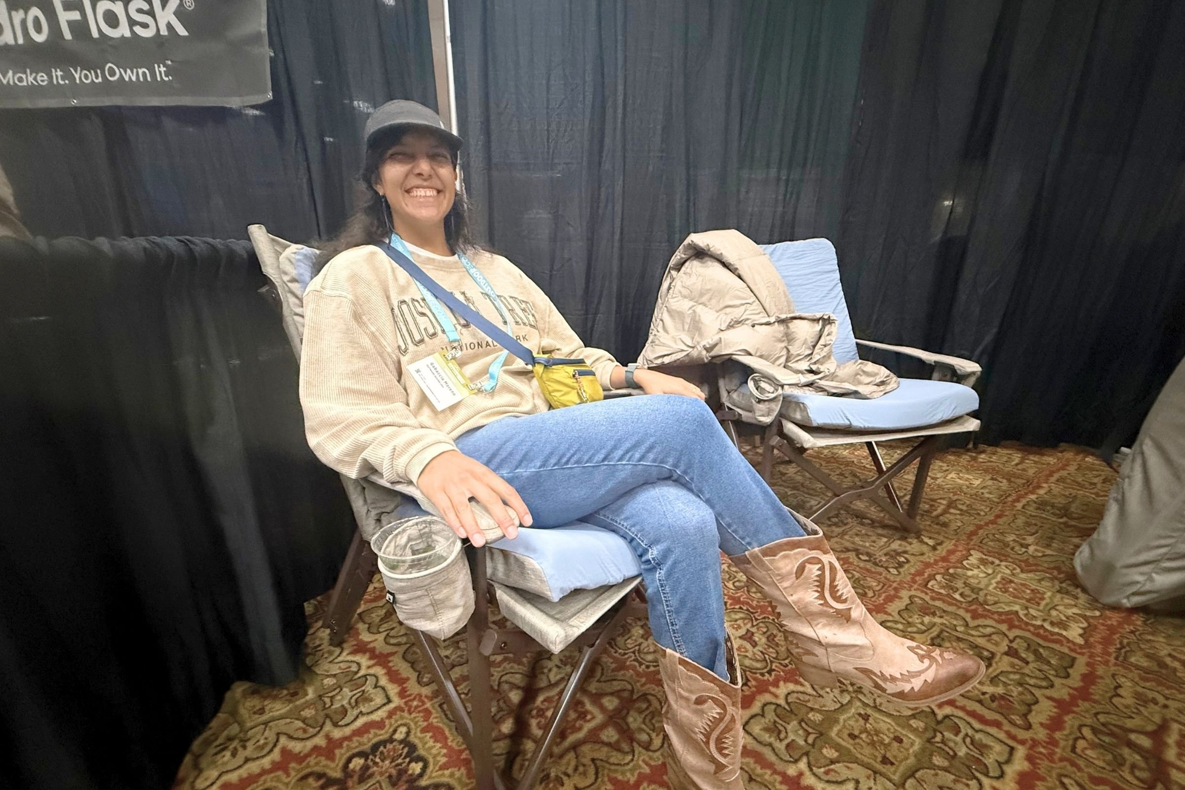 A woman sits in a chair wearing cowboy boots at the 2026 Outdoor Media Summit.