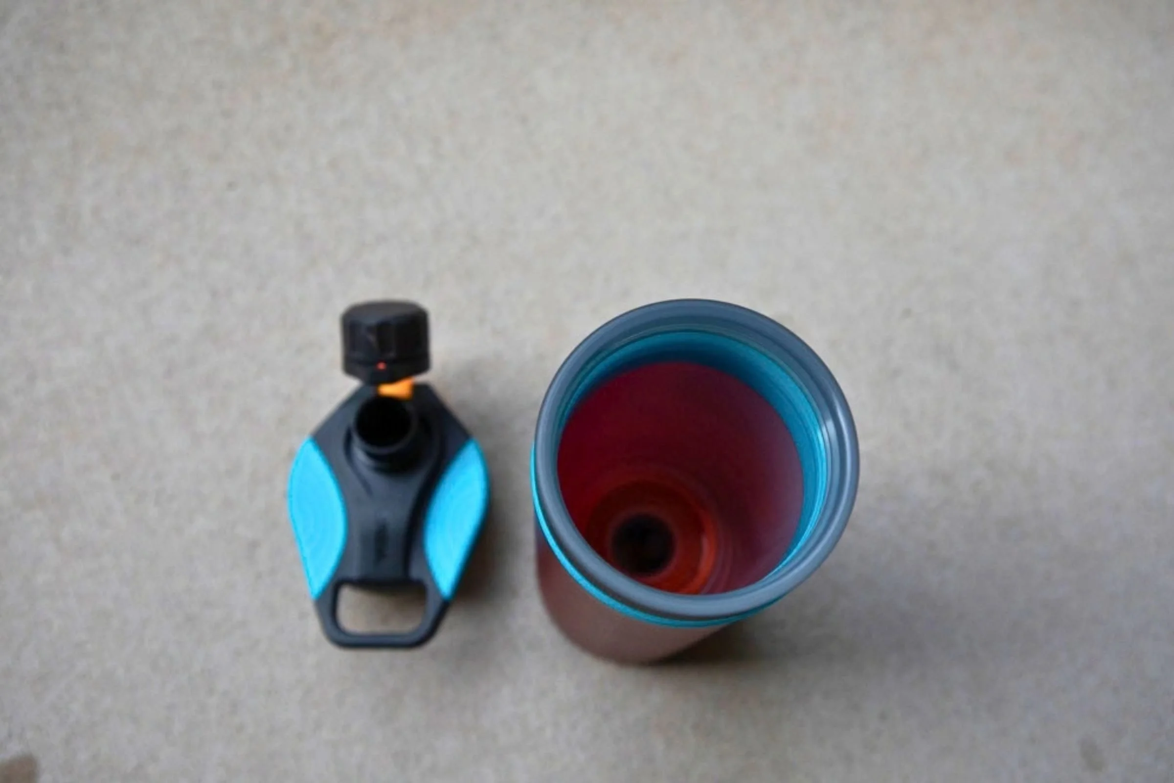 A blue and black Grayl GeoPress Purifier with its mouth opening visible.