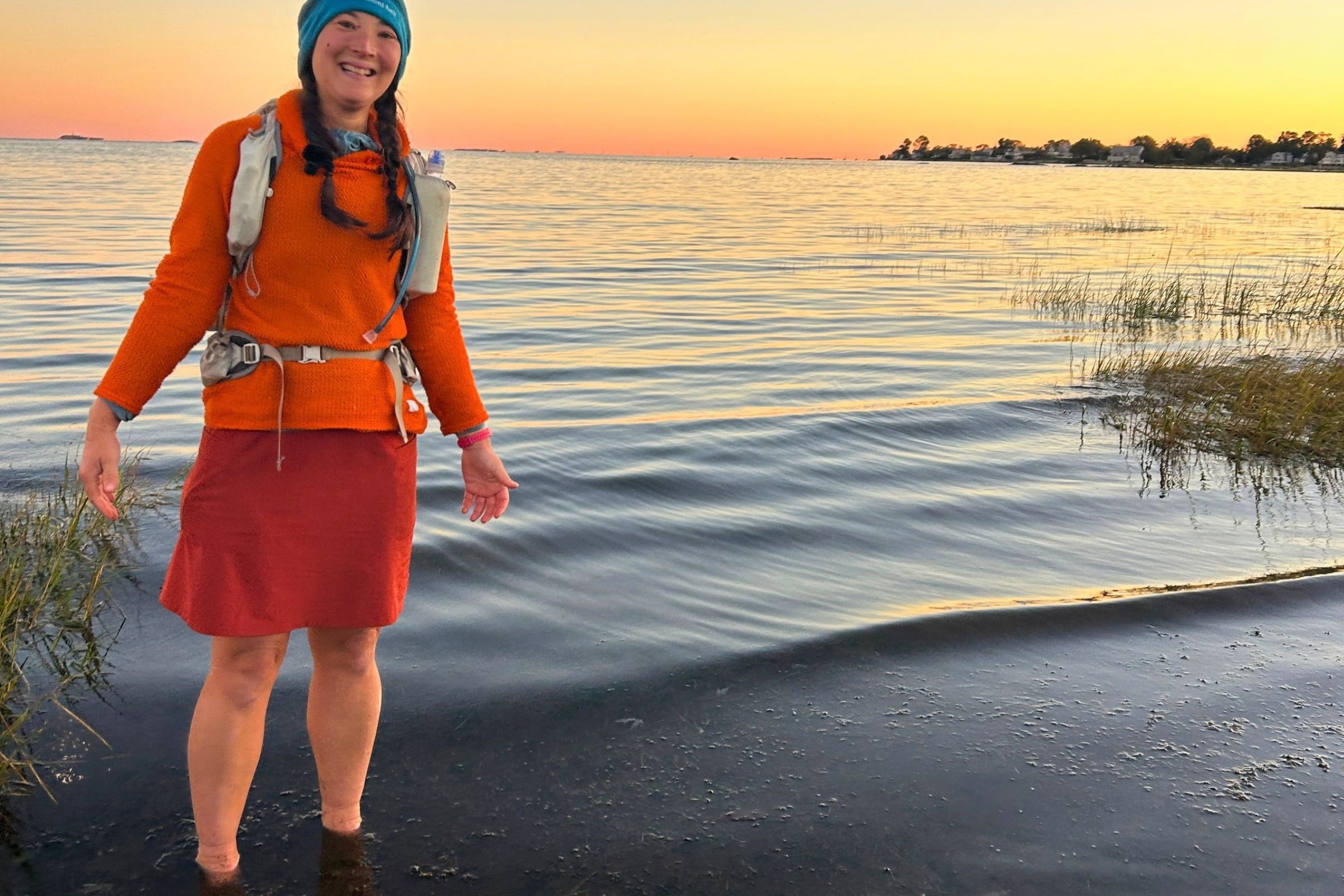 The LEVE Outdoors Alpha hoodie is hunter orange and was helpful for visibility in addition to warmth. Here, I wore it for my finish photo while putting in my feet in the cold water of Long Island Sound.