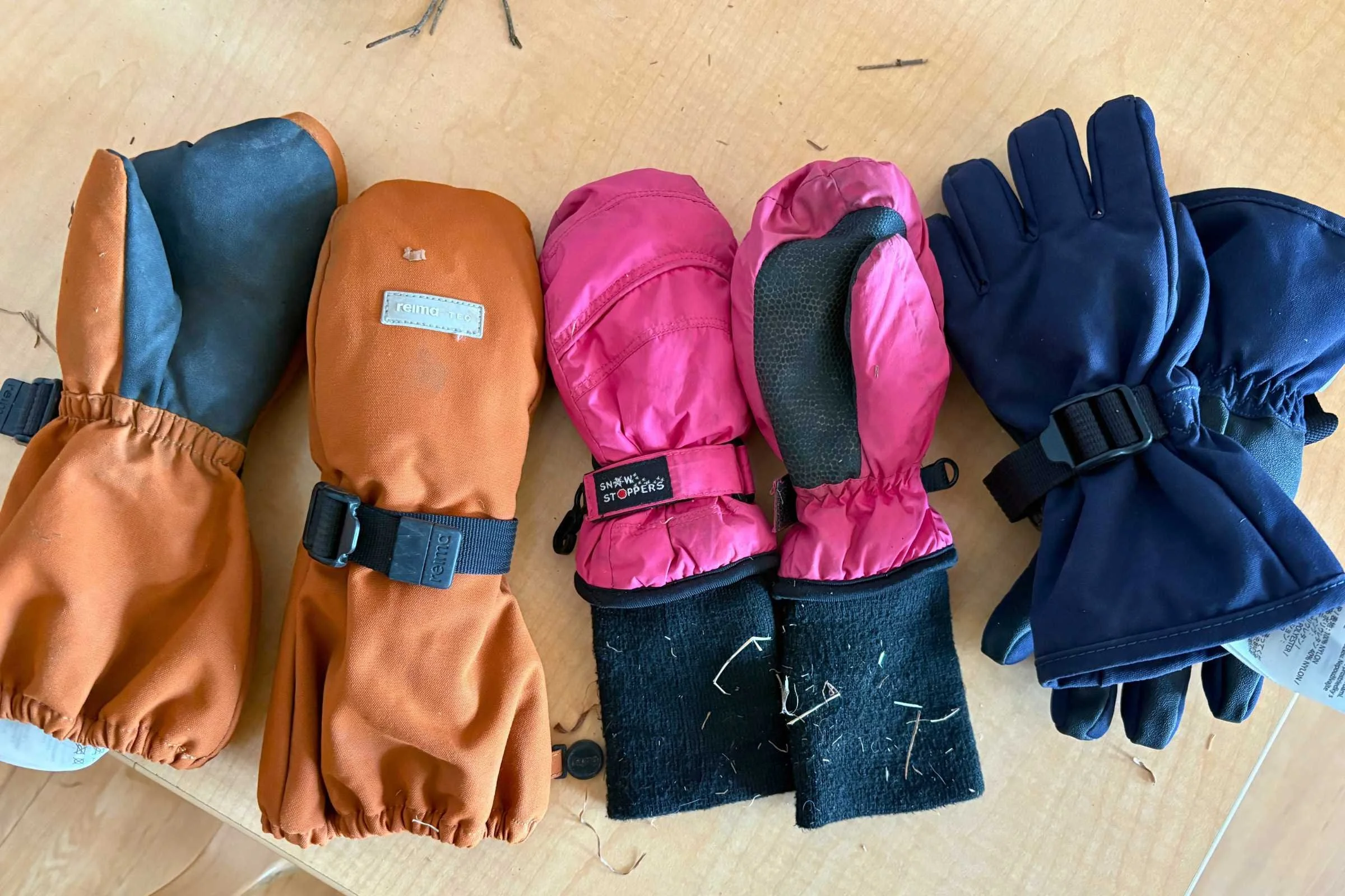 The Reima Ote, Snowstoppers, and Reima Tartu mittens and gloves laid out on a table