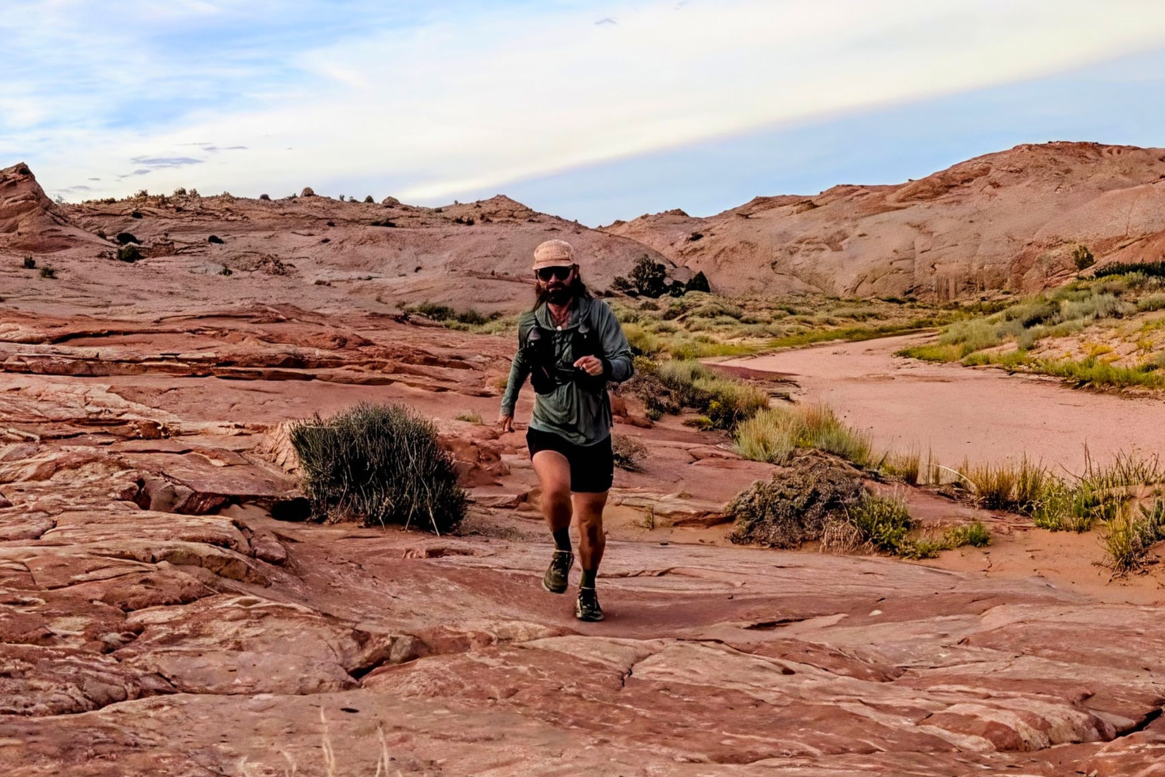 Man running in Altra Olympus 7 shoes on rocky terrain.