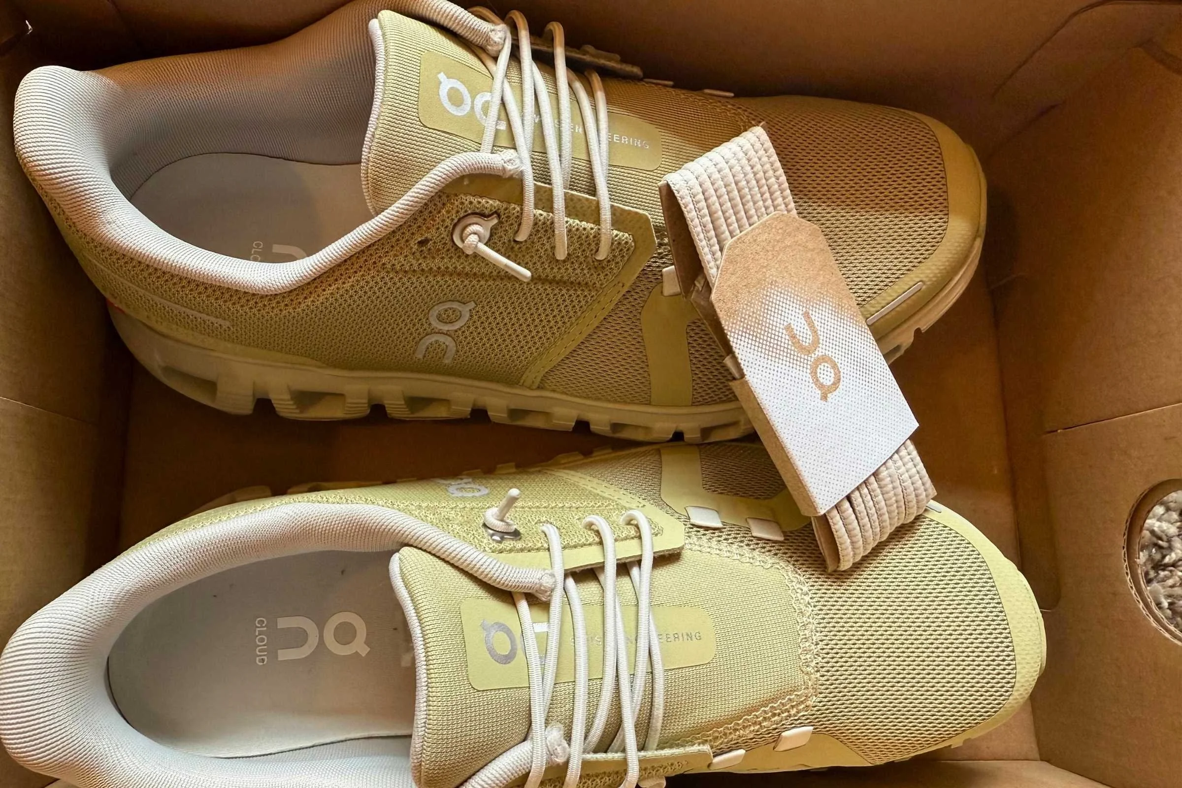 green pair of on cloud 6 in the shoebox with extra laces