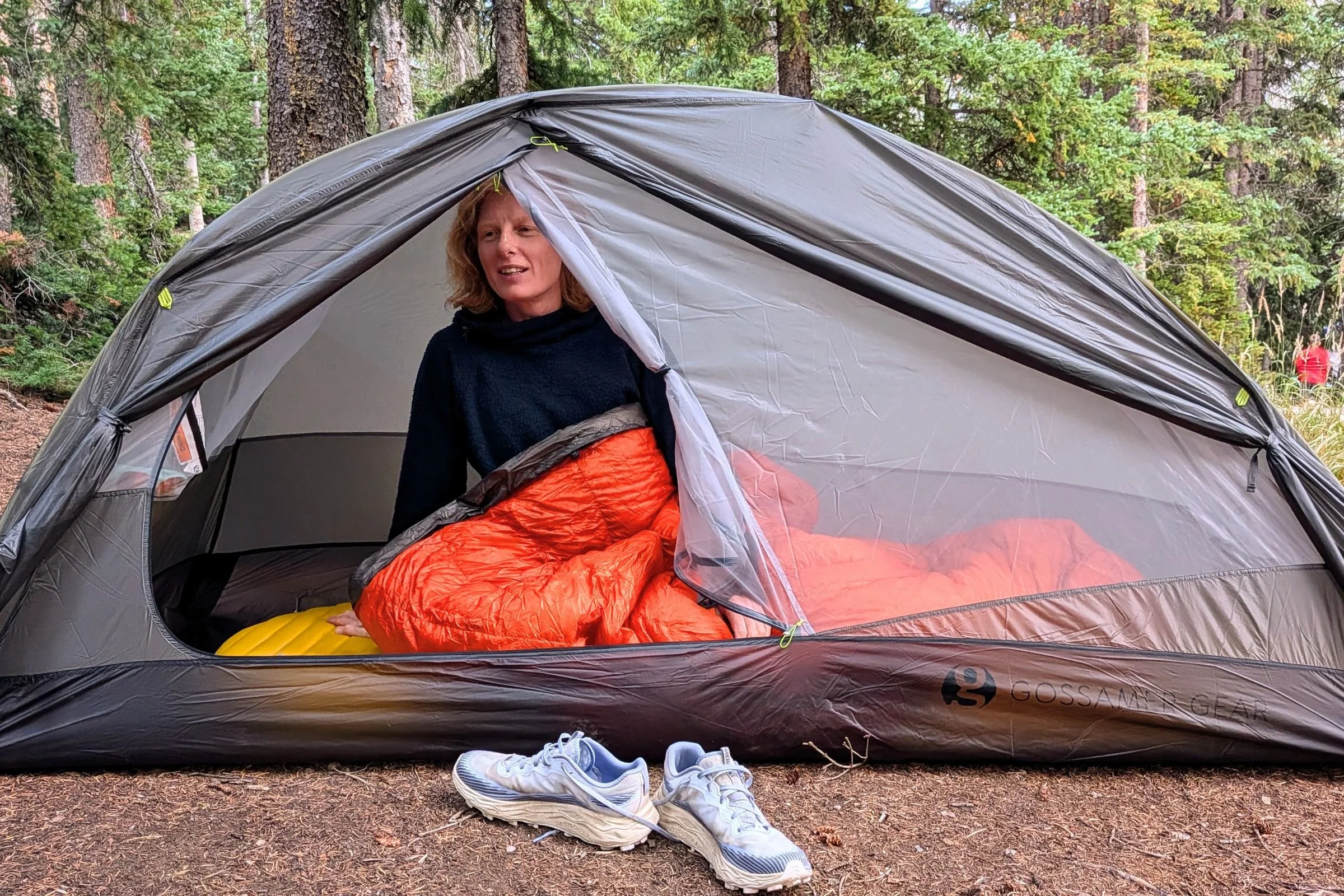A tester sits in a sleeping bag inside Gossamer Gear The Free with its doorway open.