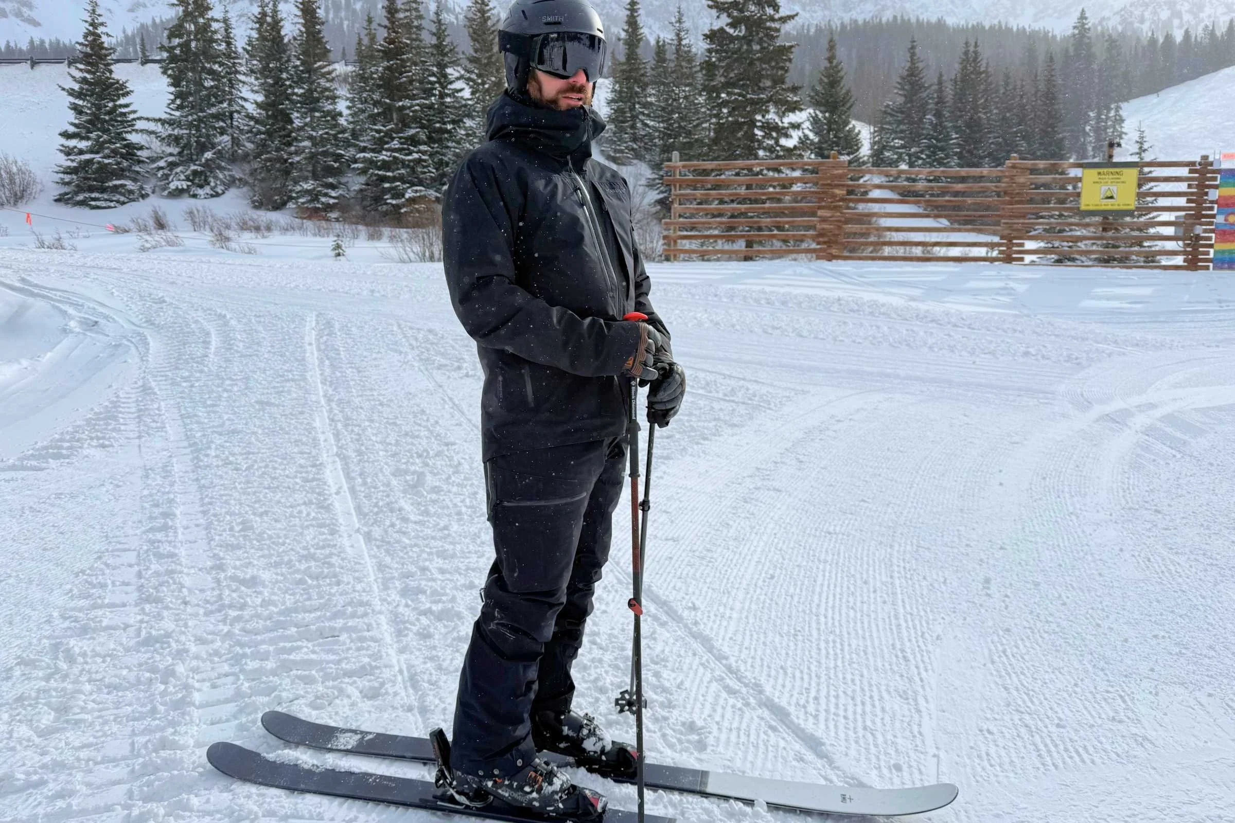 a skier wearing the Norrona lofoten GORE-TEX insulated jacket at a resort