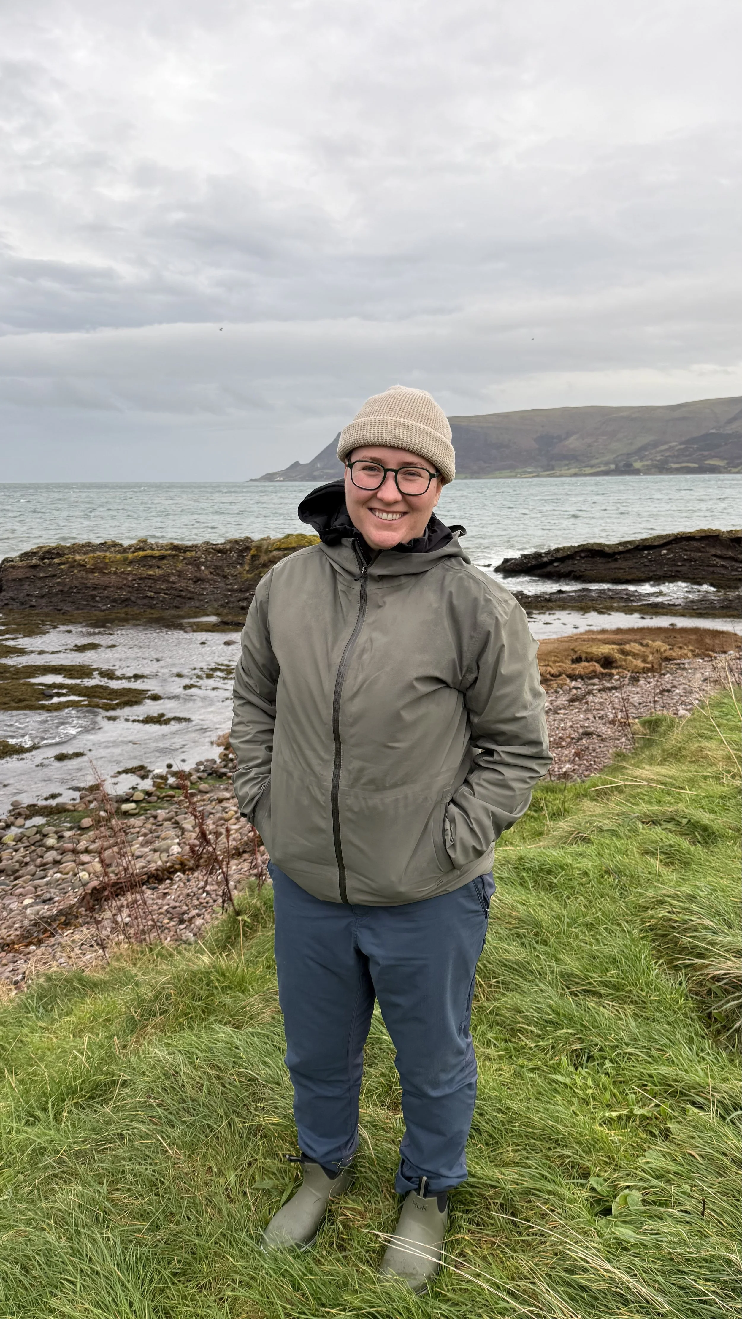 the author on a rocky shoreline on an overcast day