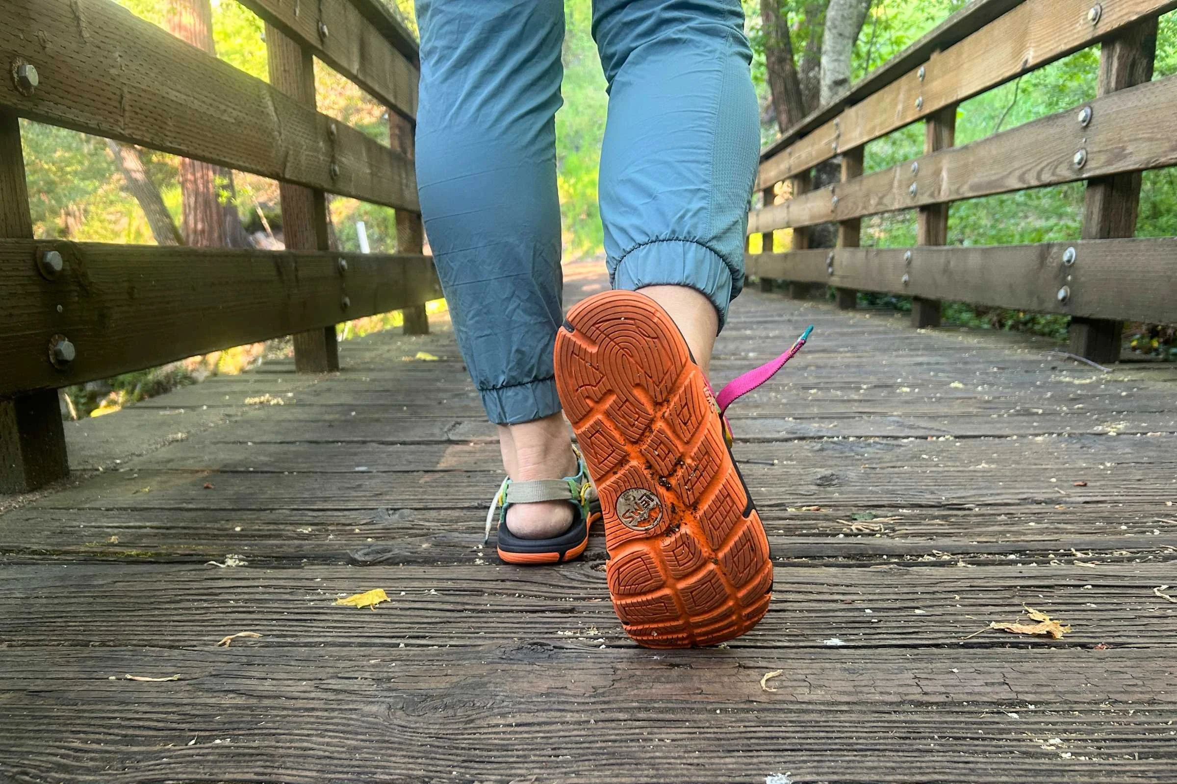 Person walking away from the camera with a close up on the outsole of the Lems Switchback Sandal Knit
