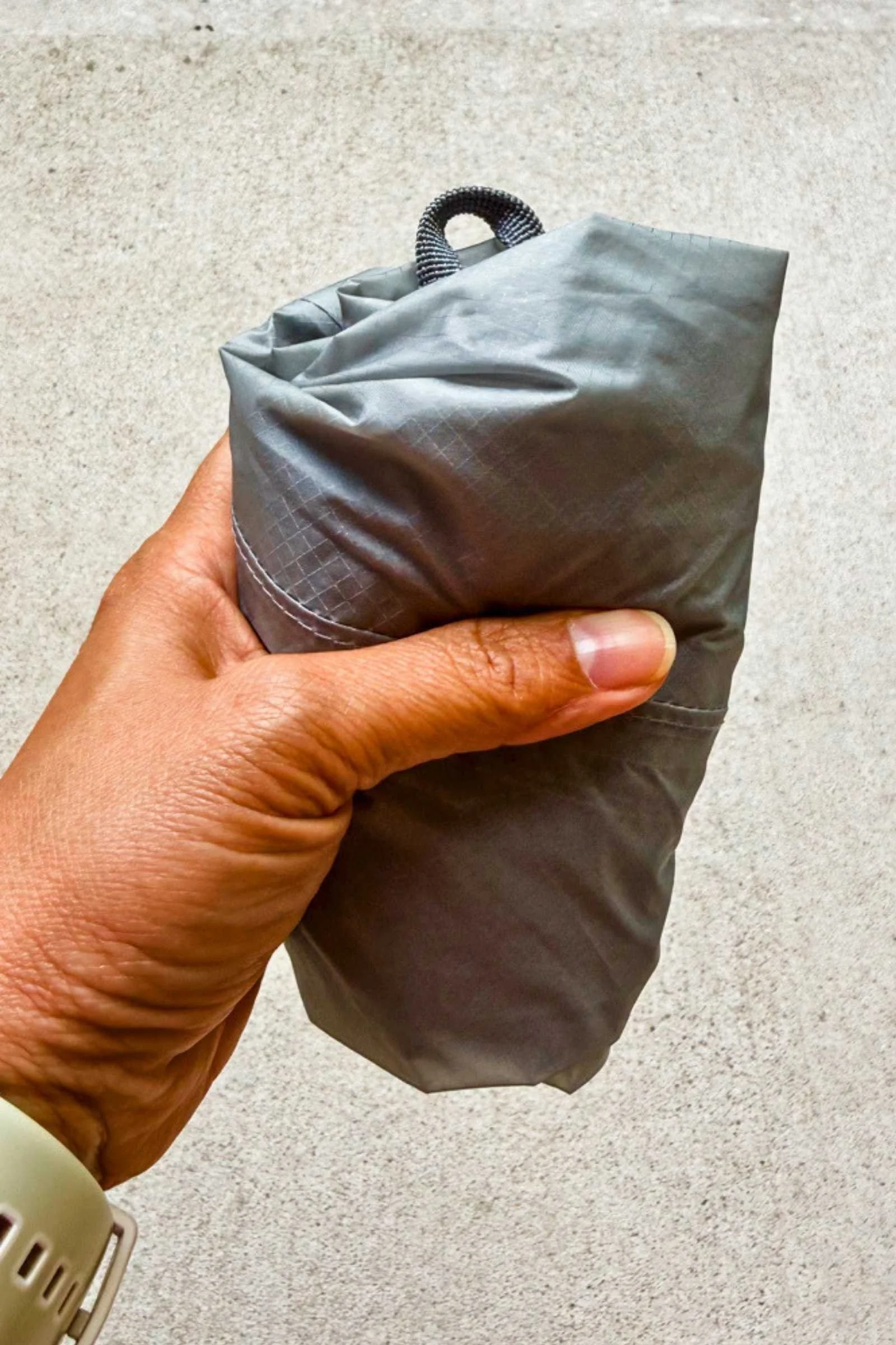 Demonstrating how small a packable backpack can fold down to