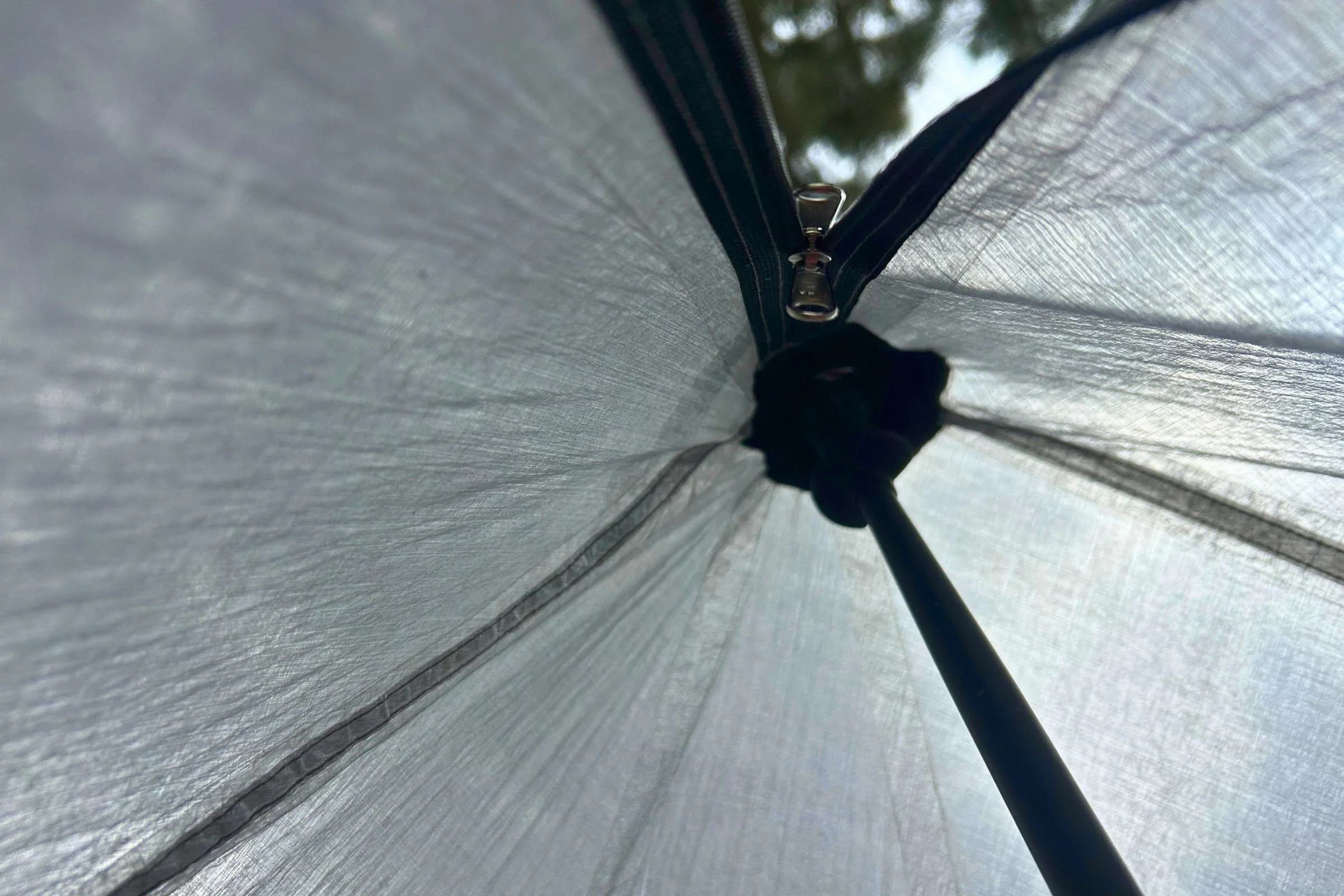 A close-up of the white DCF interior fabric of Gossamer Gear The DCF Whisper Tent, showing umbrella-like structural details.