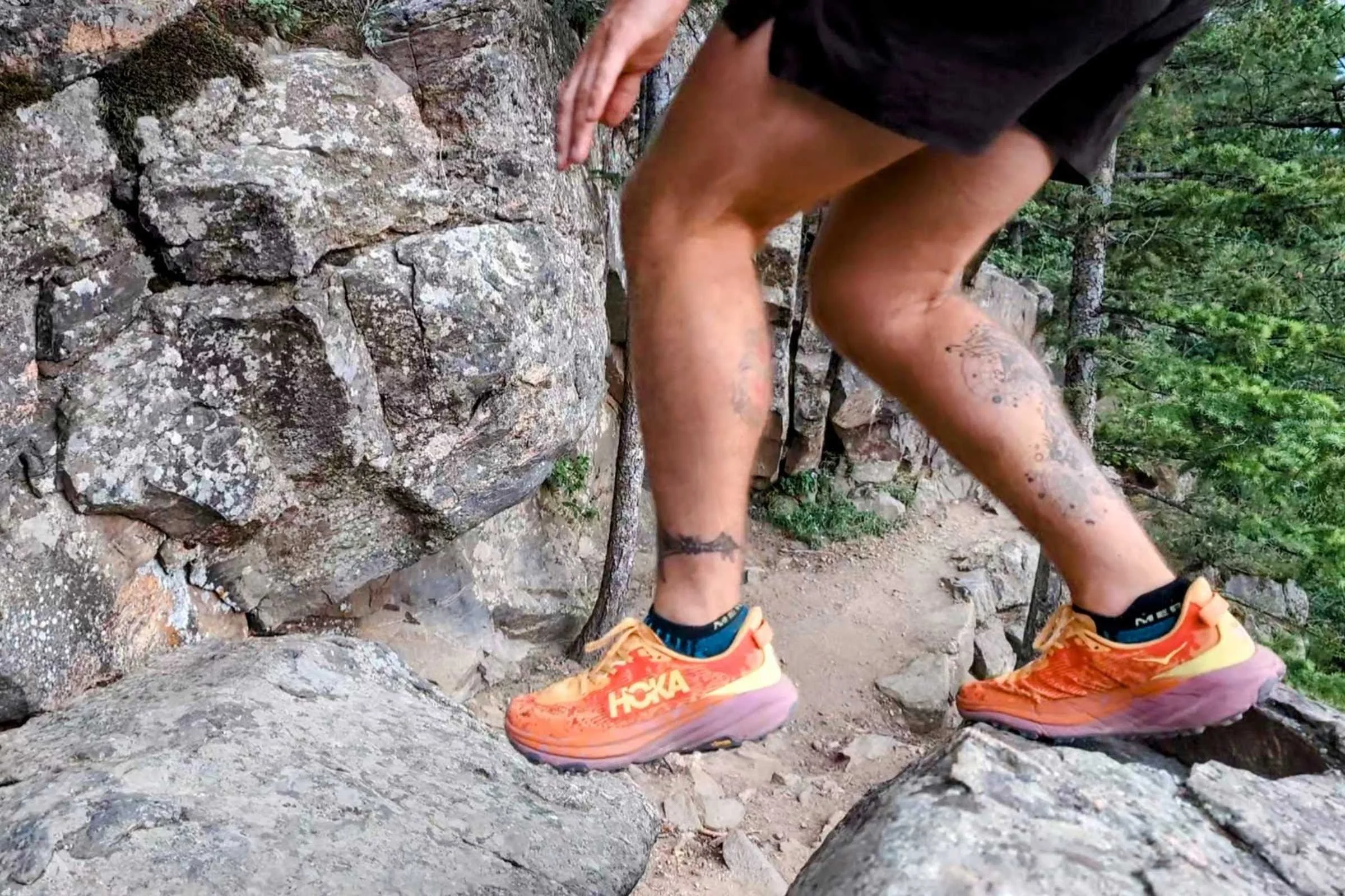 Man trail running on rocky terrain in the Hoka Speedgoat 6