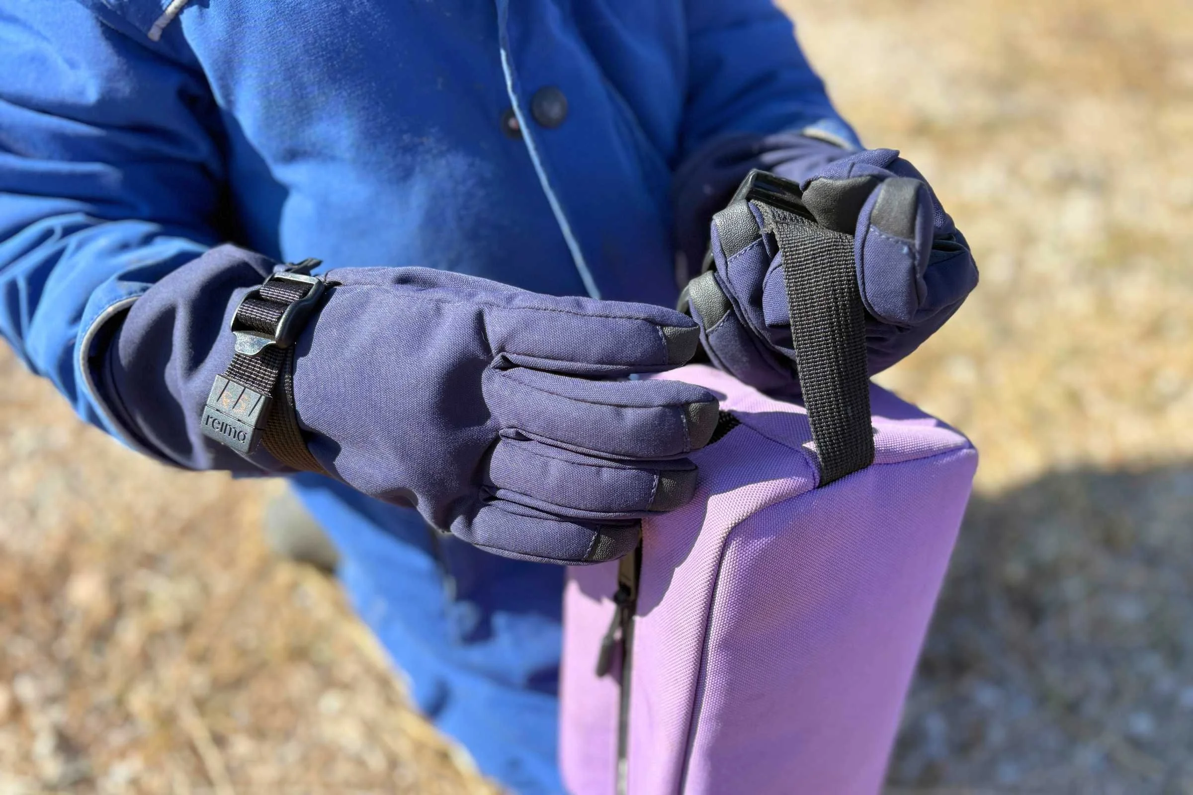 Child caring lunch box while wearing Reima Tartu gloves