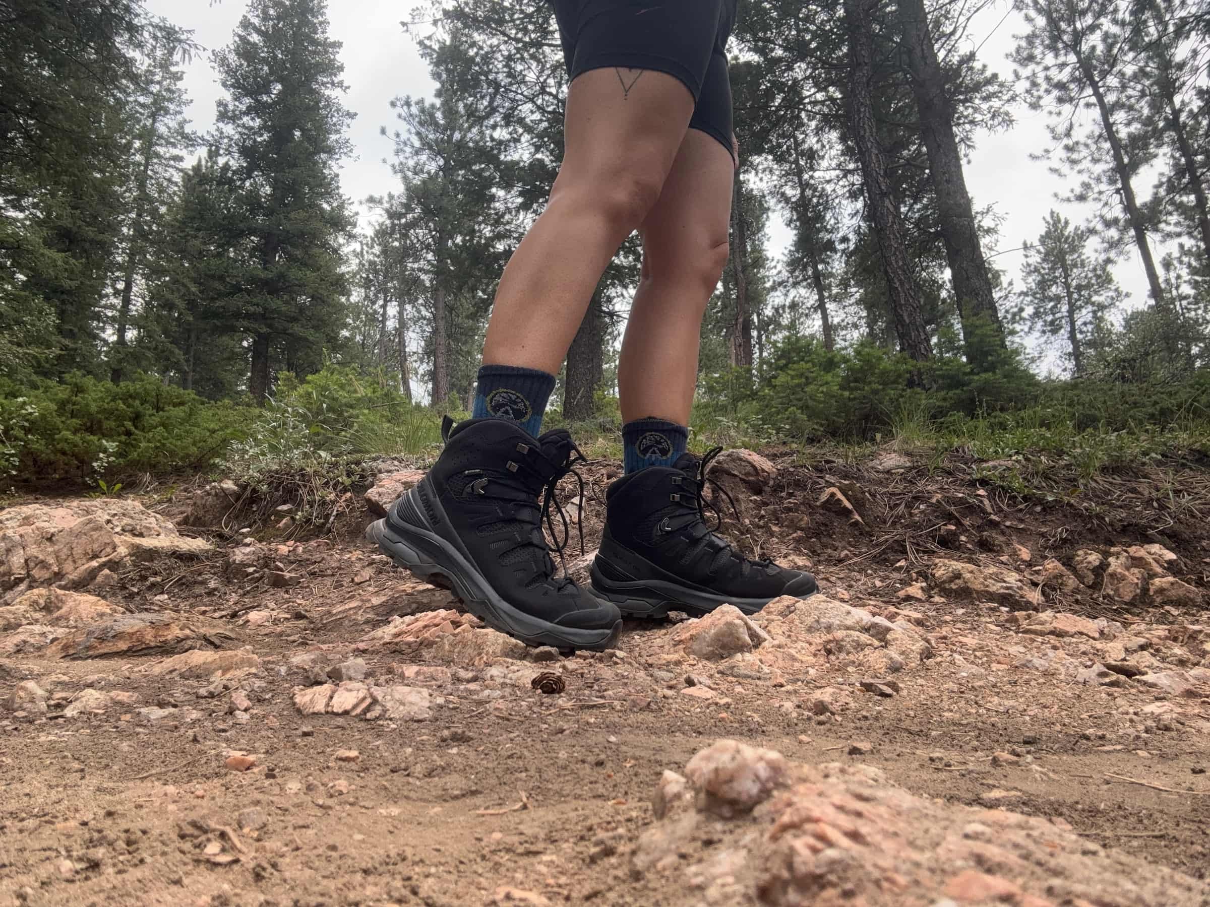 Close-up on the Salomon Quest 5 boots on a hiker in the woods