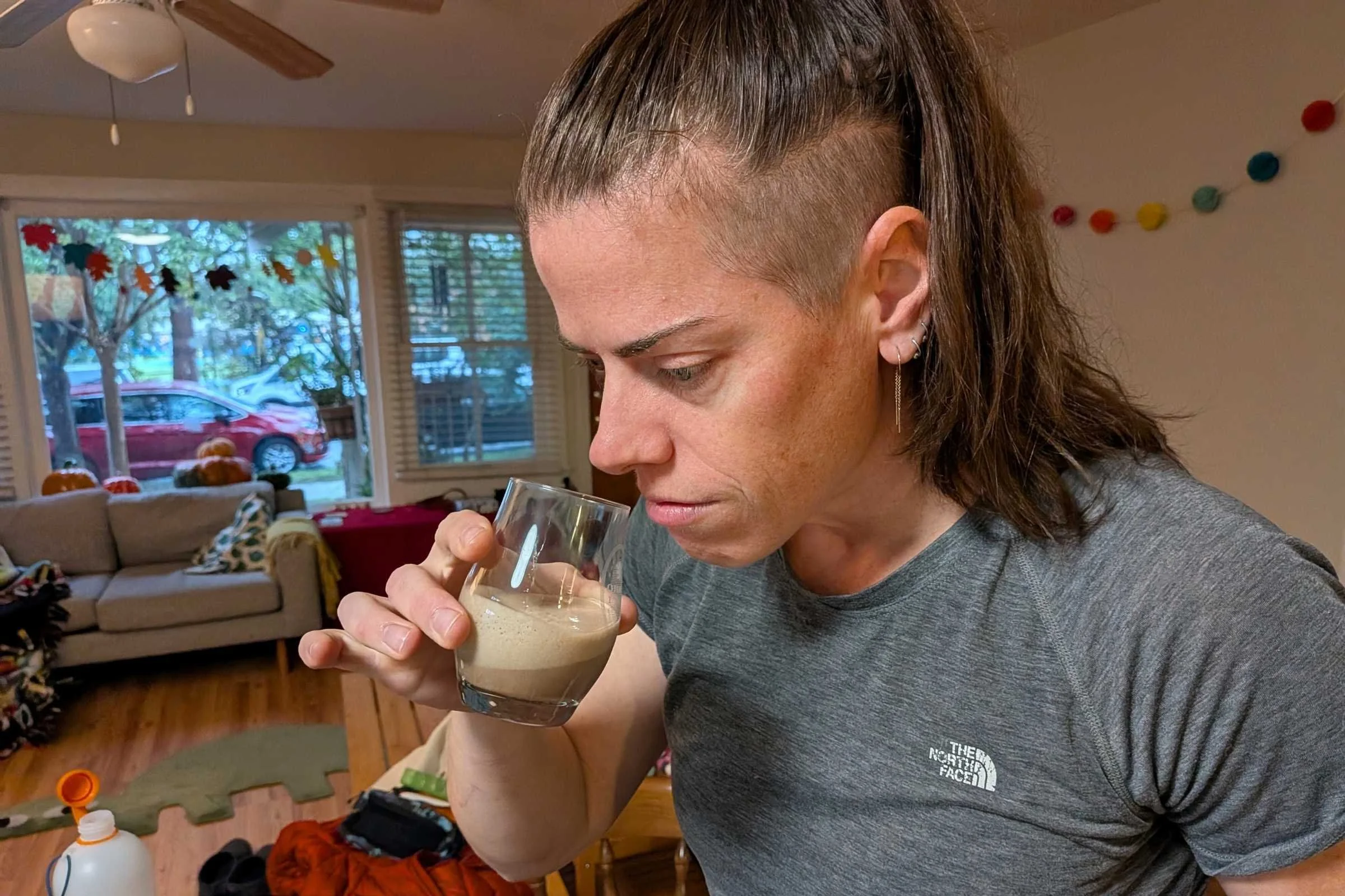 Women about to take a sip of a protein powder sample in a clear glass