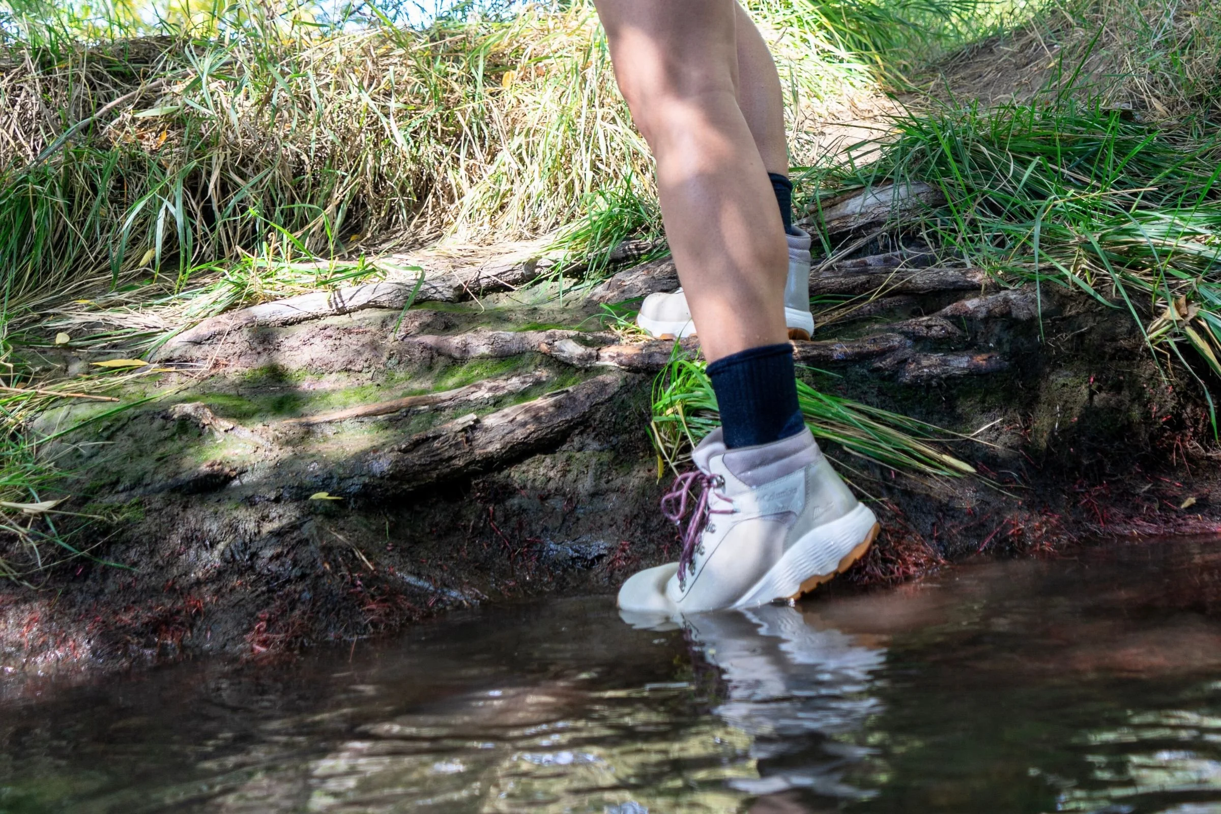 Dipping toes of hiking boots in water to test waterproofness of the Columbia Newton Wander