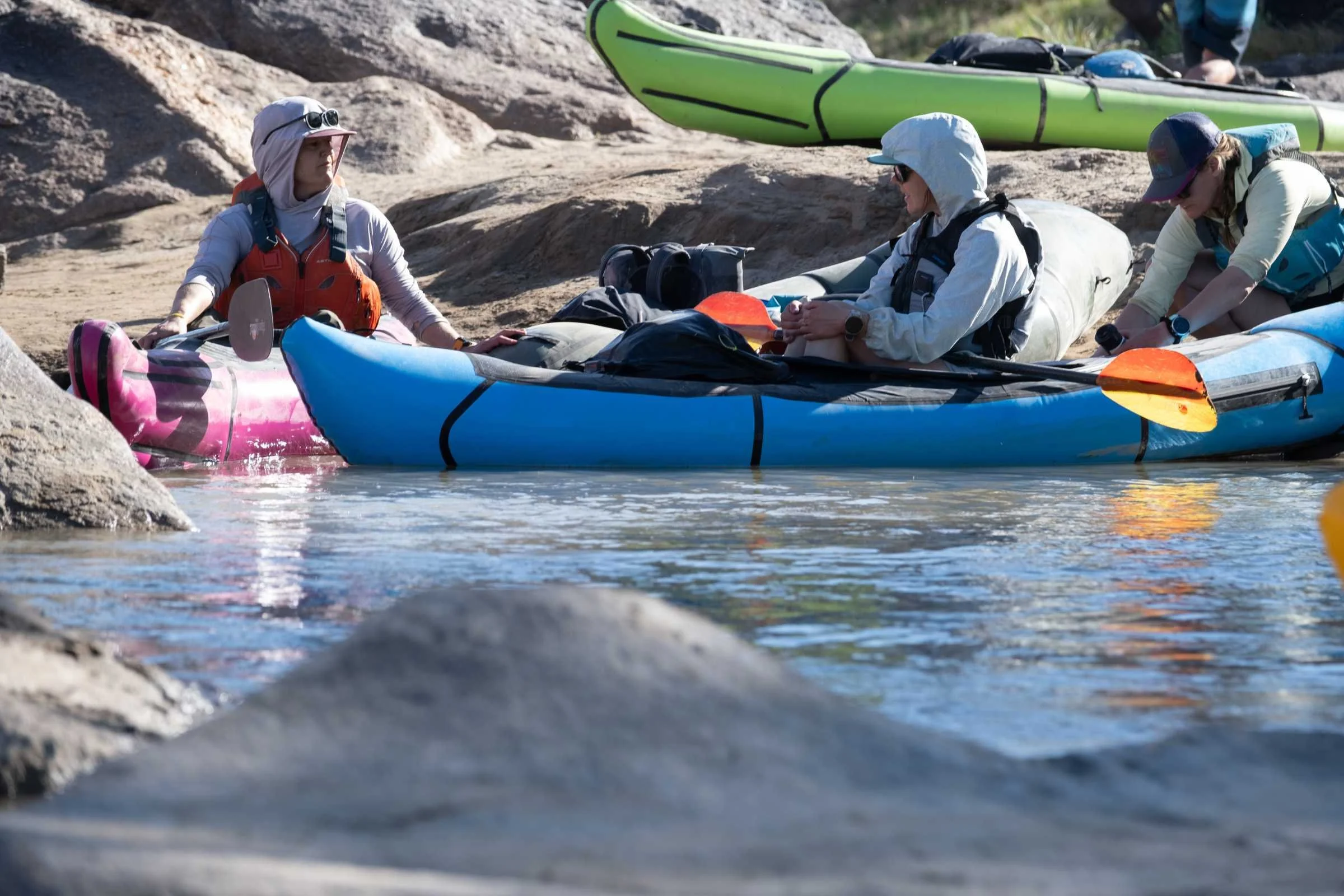 A paddler sits in an eddy in the Alpacka Raft Chinook
