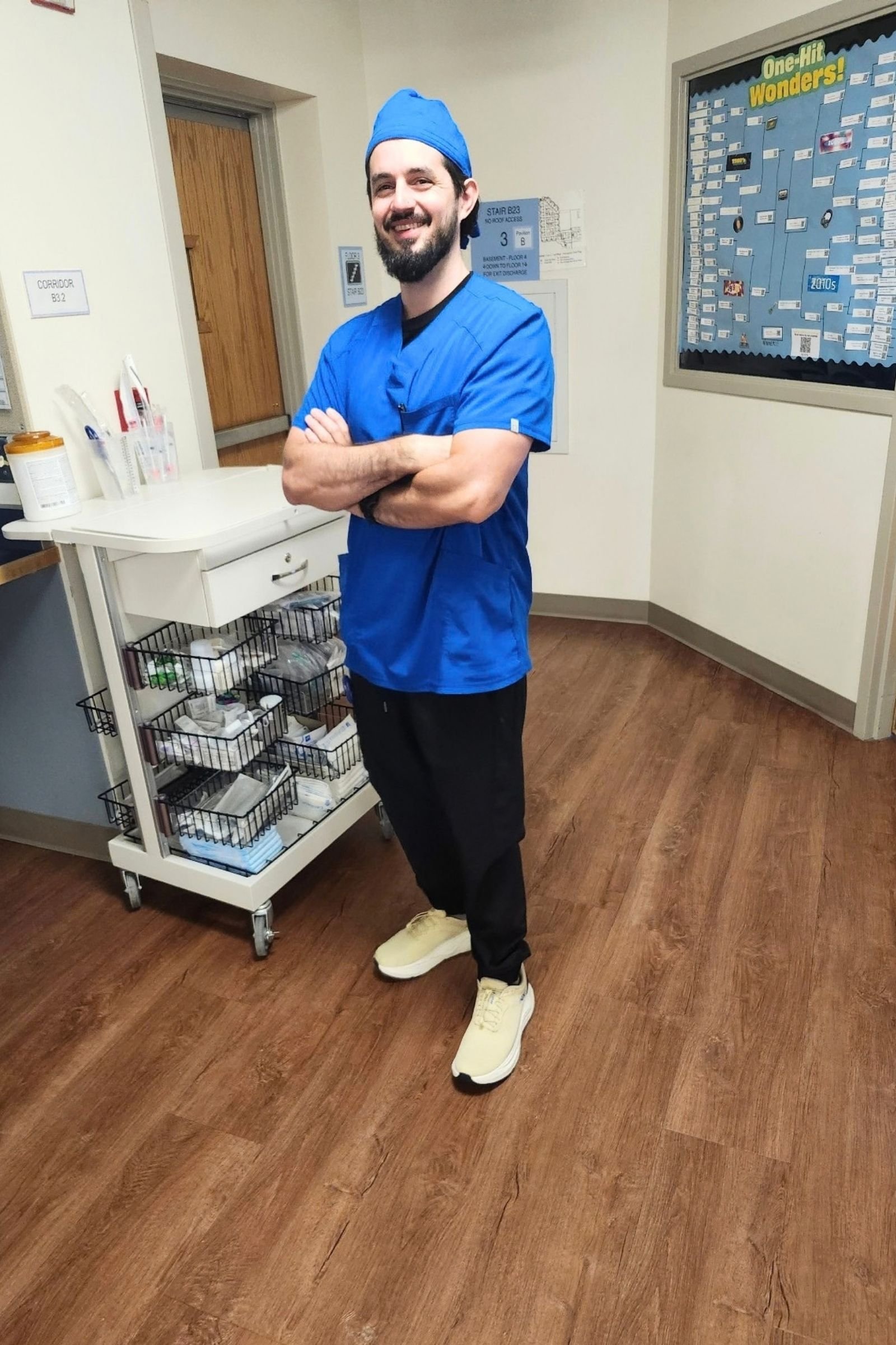 Man wearing HOKA Arahi SR shoes indoors.