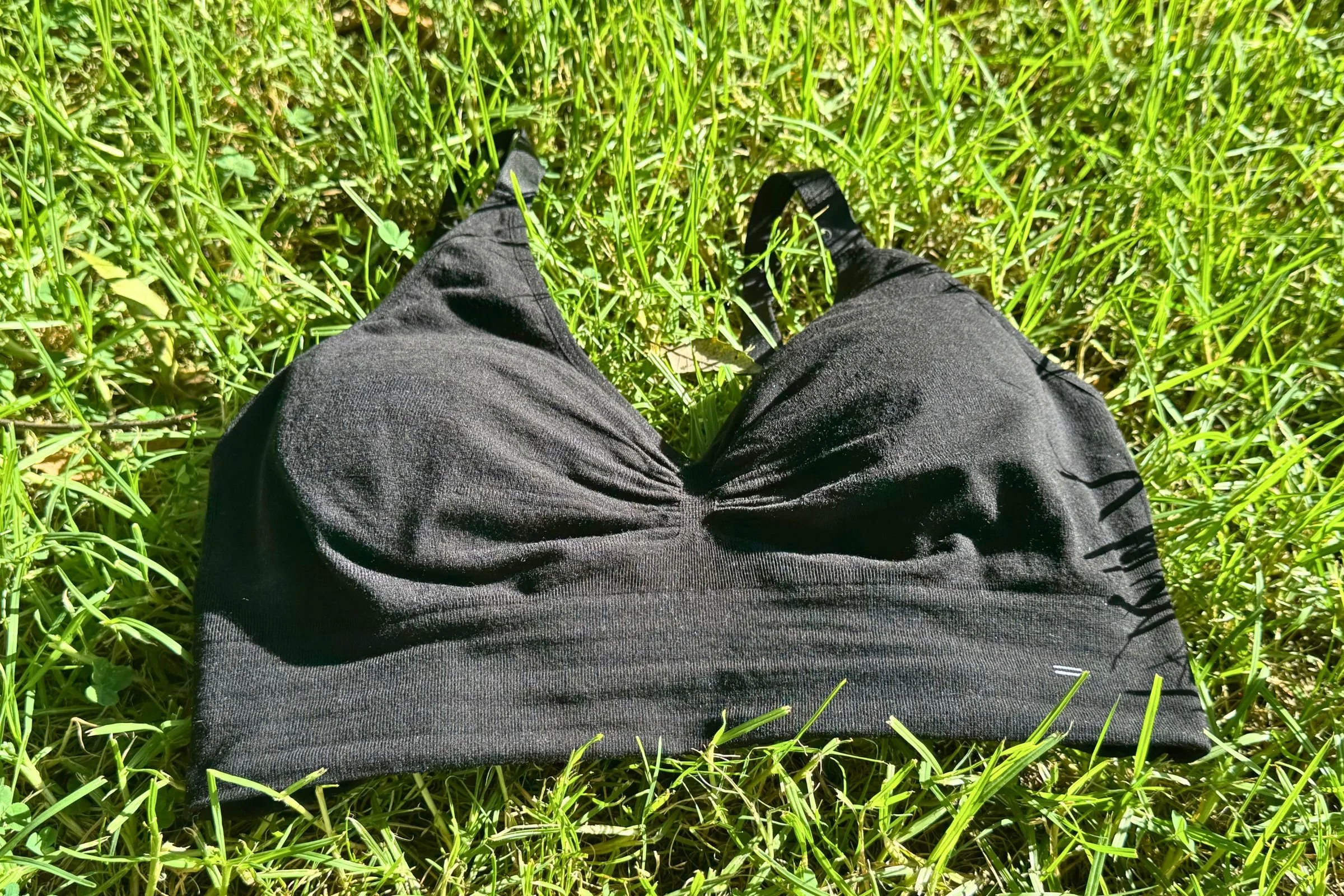 A black Branwyn Essential Supreme bra on top of green grass.