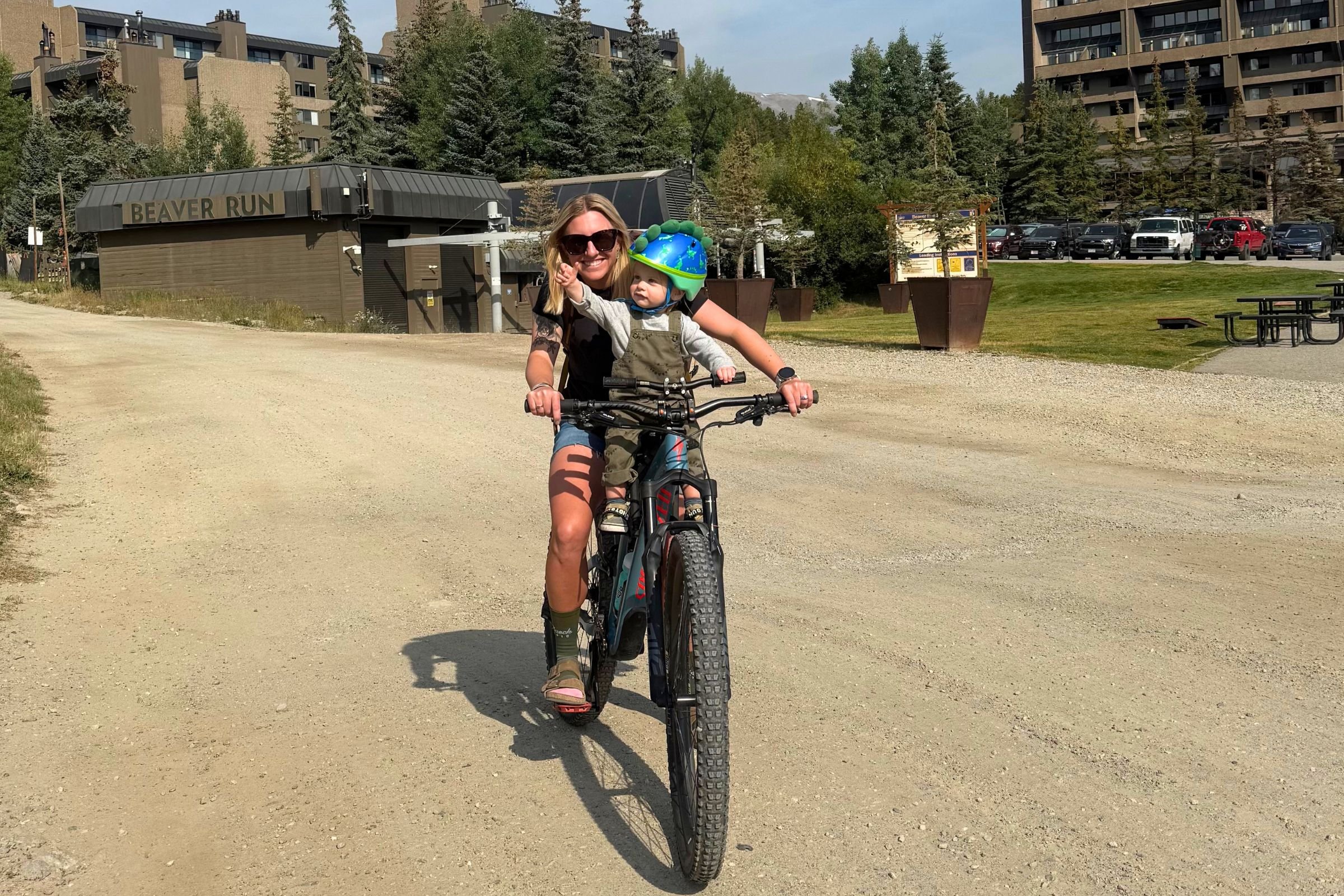 Woman and child riding together along a dirt road with the Kids Ride Shotgun Shotgun Pro Evo.