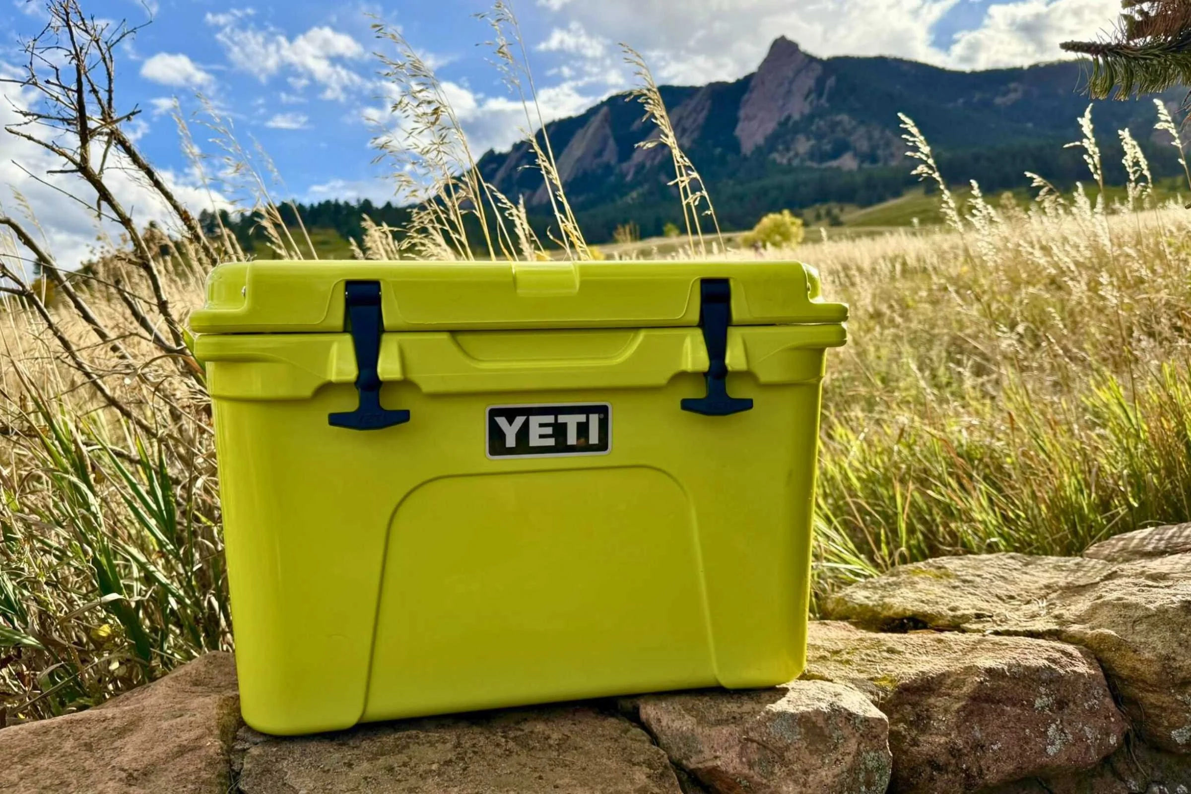 Closed YETI Tundra 35 hero shot with a grassy field and the Flatirons of Boulder, CO in the background