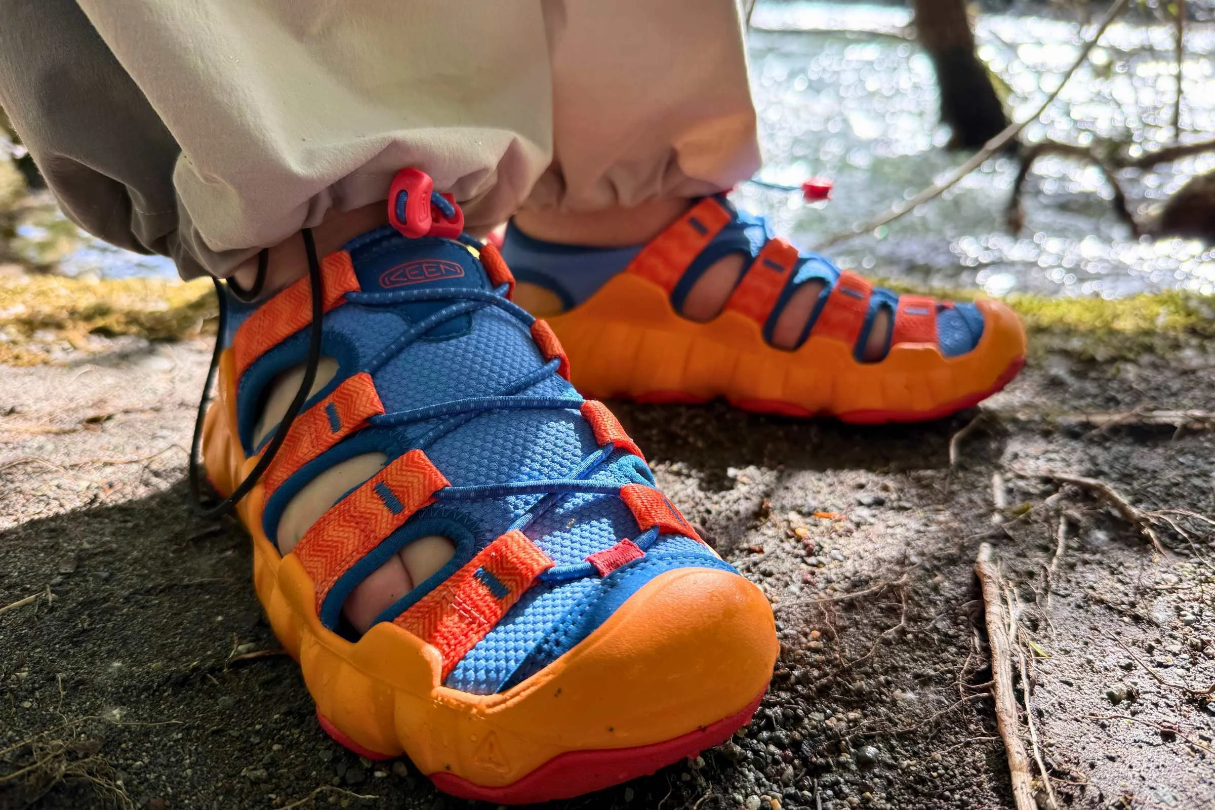 On a dirt path next to a stream in the Keen Hyperport H2 sandals
