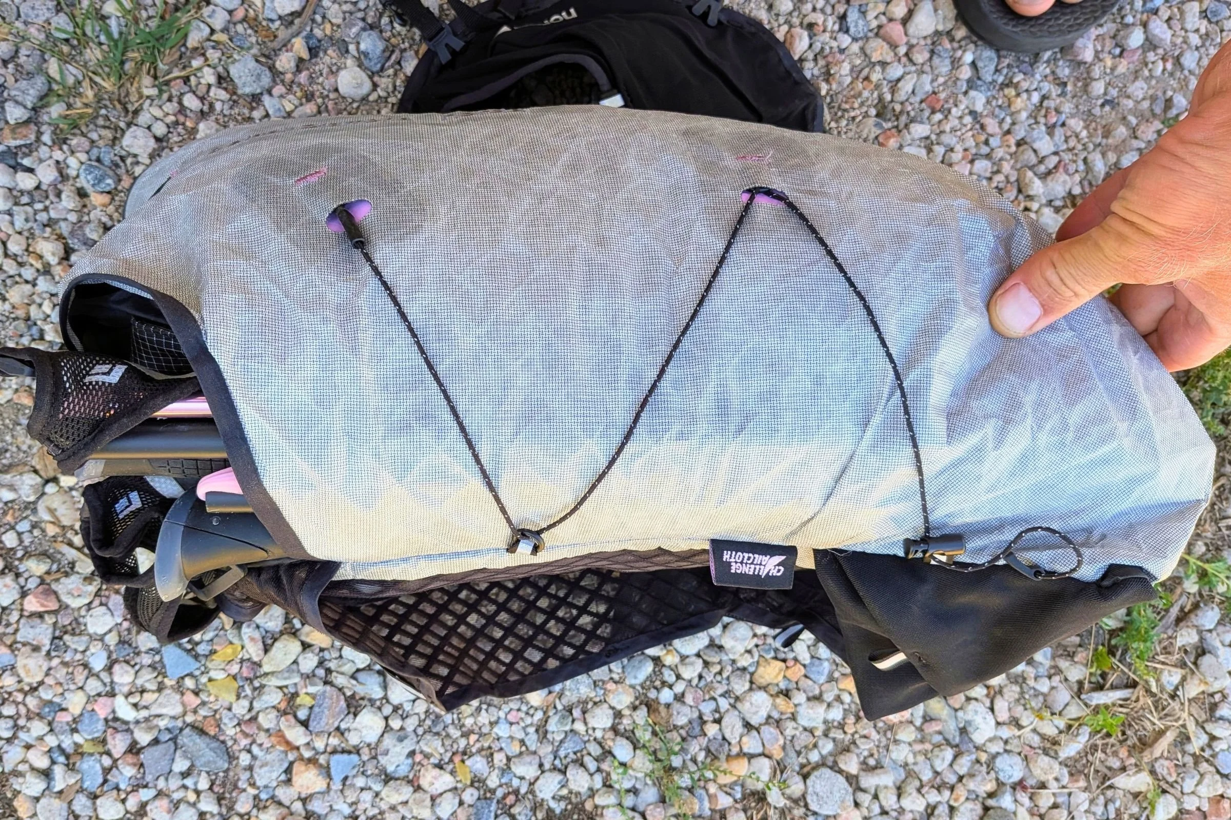 A person holds the Black Diamond Distance 15 Backpack with a small piece of cloth visible.