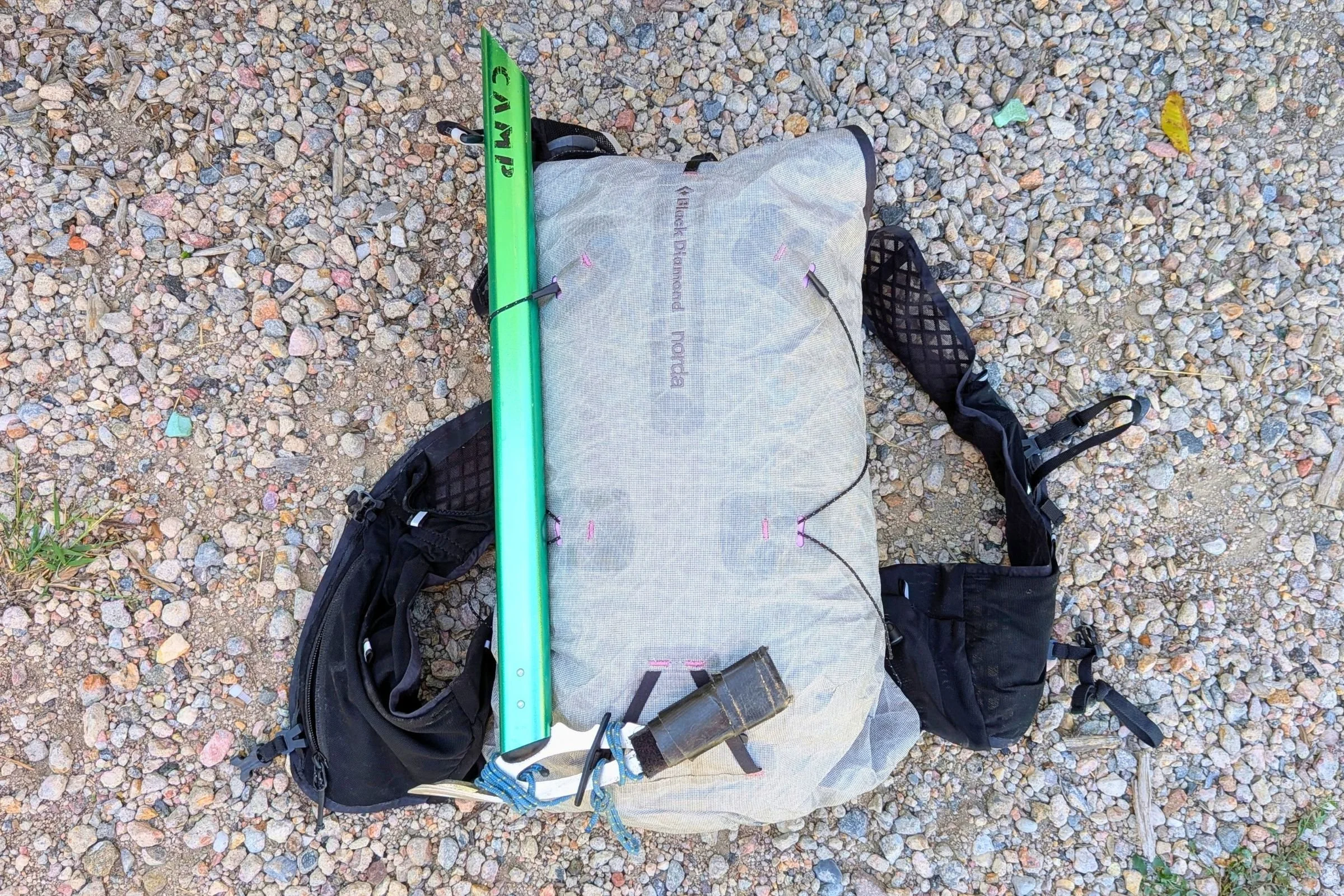 The Black Diamond Distance 15 Backpack is shown with a green pole and another bag.