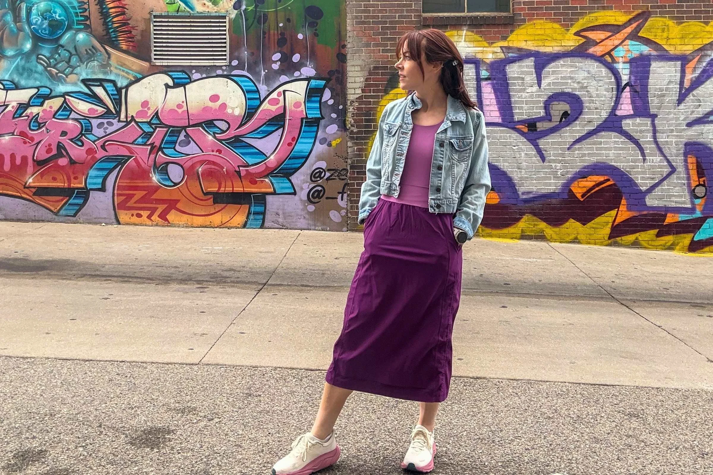 Woman wearing the Title Nine Limitless Midi Dress in an urban setting in front of a graffiti wall