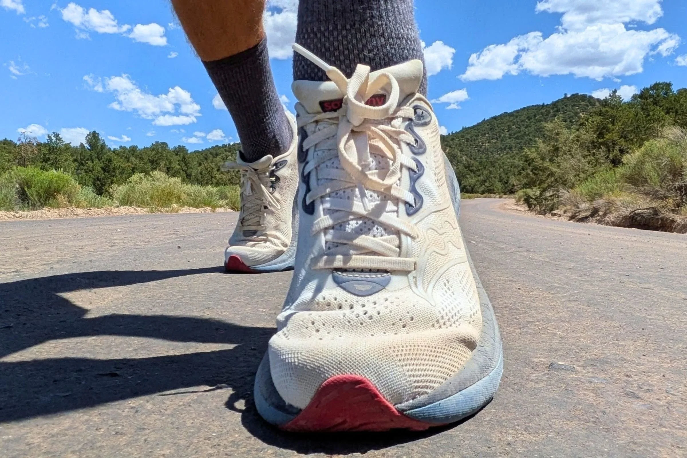 Saucony Ride 19 Road Running Shoes worn by a runner on a paved road.