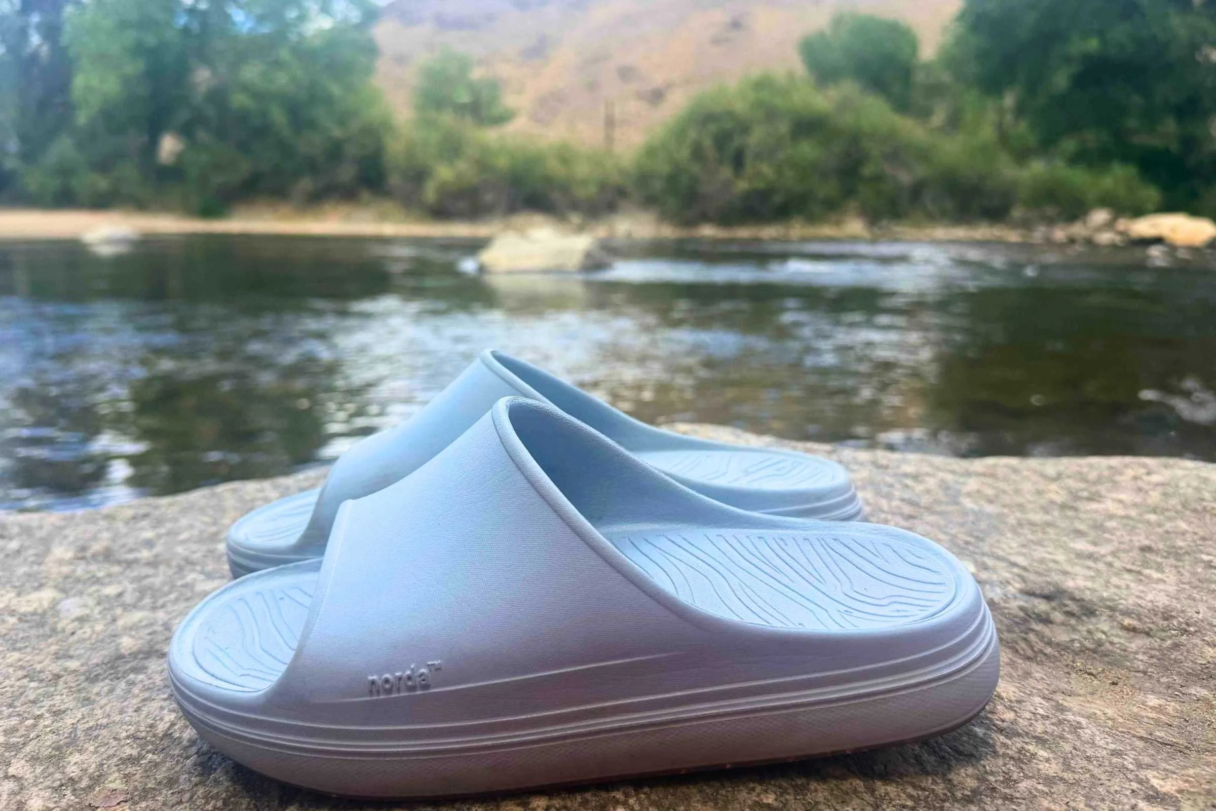 Norda 008 Recovery Slides: A pair of blue slides on a rock by a river.