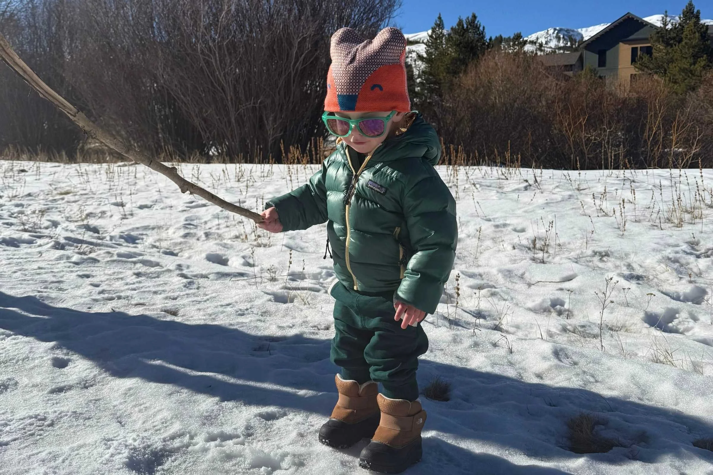Child wearing snow boots walking through snow