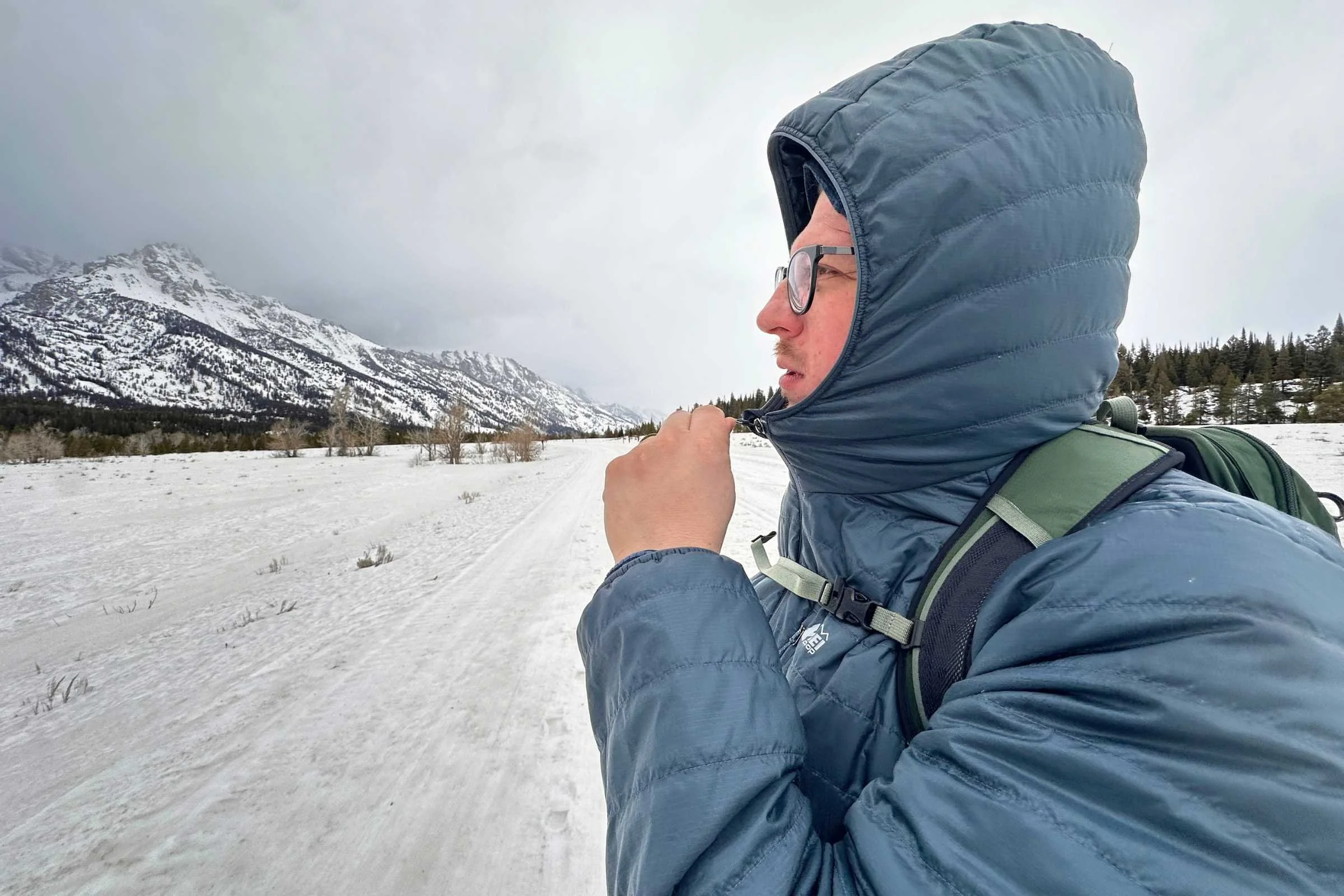 Zipping up the REI Microtrek while wearing the hood.