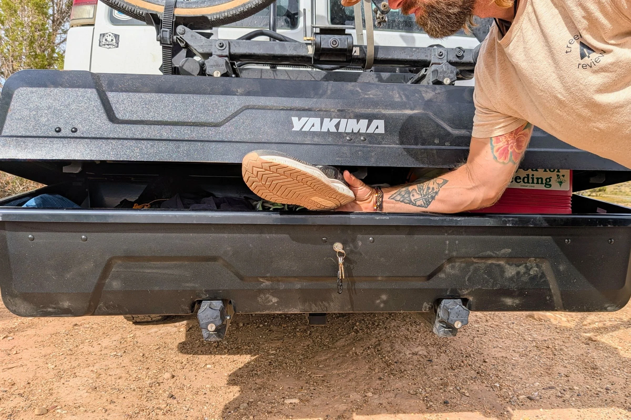 Tester reaching into a Yakima EXO GearLocker with its lid partly blocked by the EXO TopShelf above.