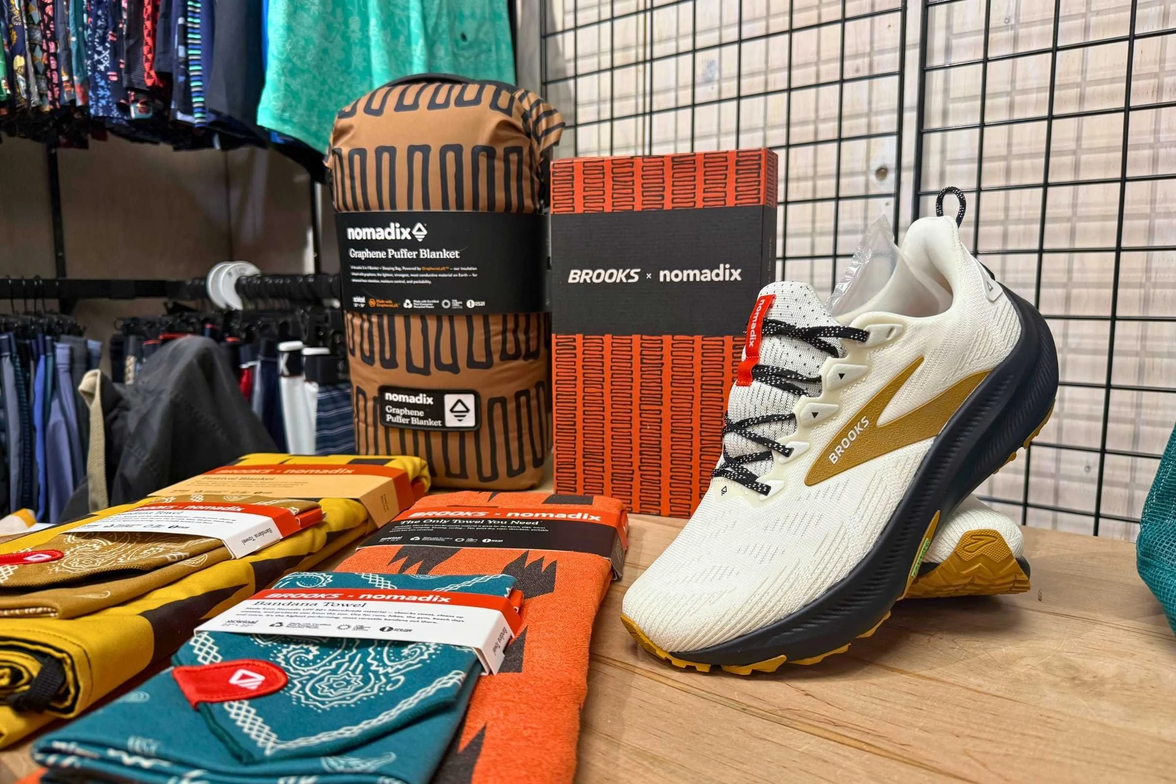 A Brooks × Nomadix collaboration featuring the Brooks Ghost Trail running shoe alongside Nomadix blankets and accessories, highlighting the brands’ partnership in the growing trail running market.