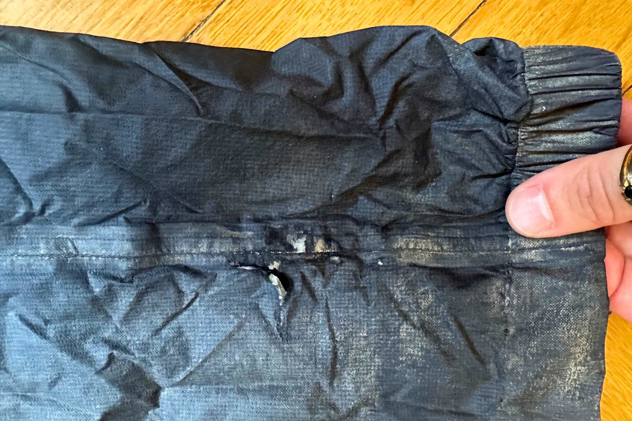 Tear on the right leg of the Outdoor Research Helium UL rain pants.