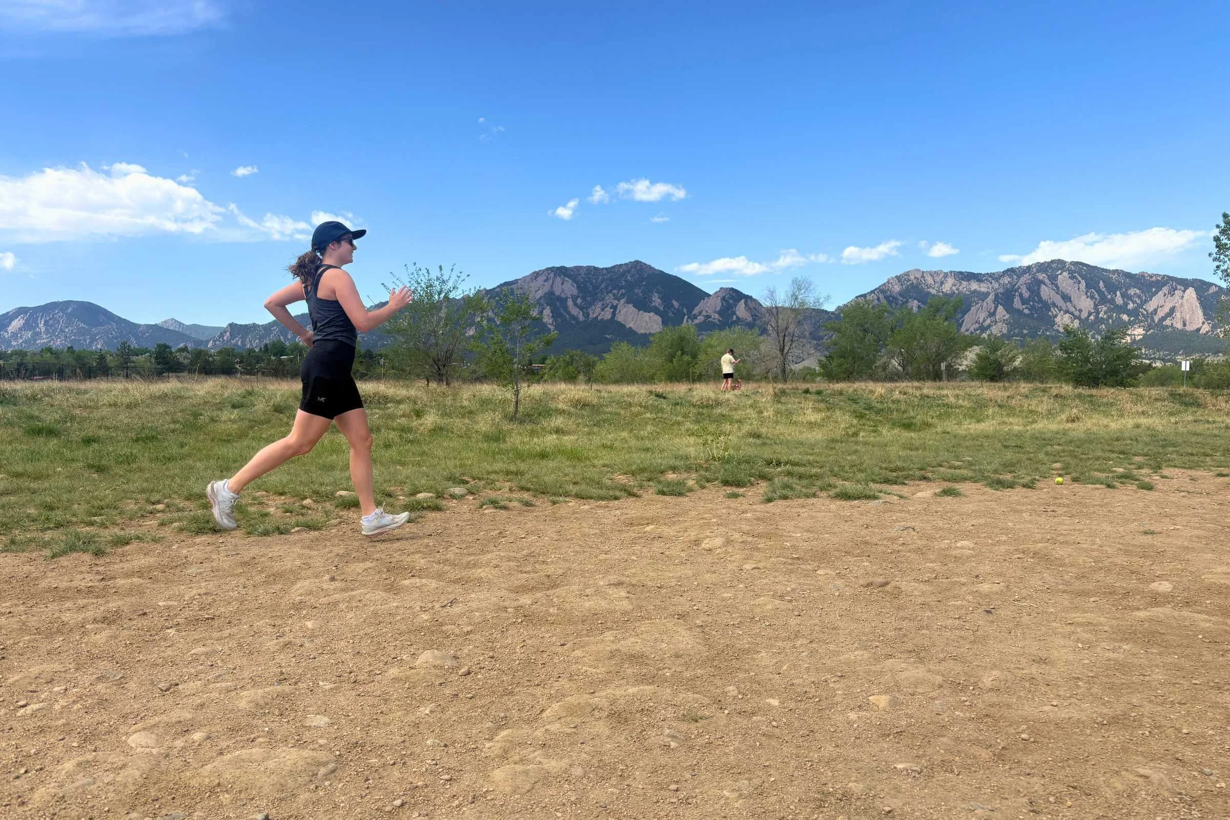 A person runs on a dirt path with wearing Arc'teryx